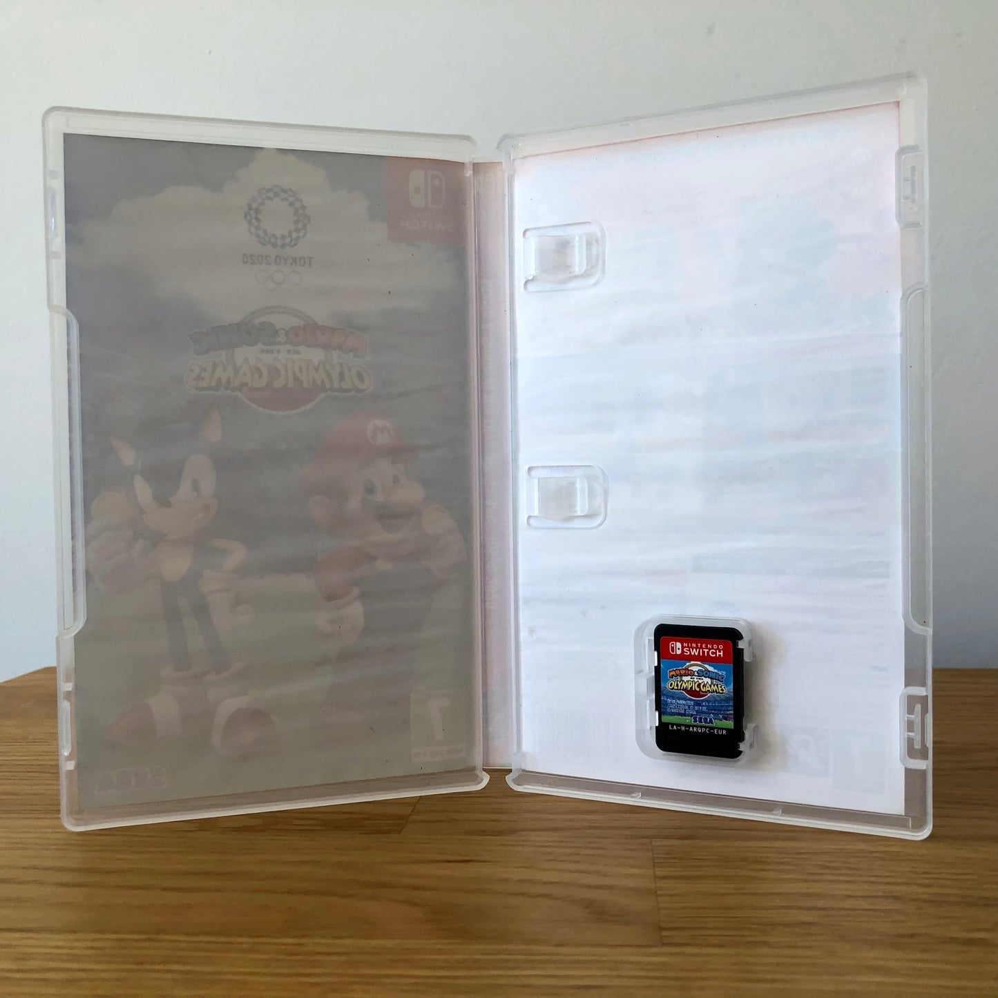 Inside the case of Mario & Sonic at the Olympic Games: Tokyo 2020 for Nintendo Switch, showing the cartridge and case design.