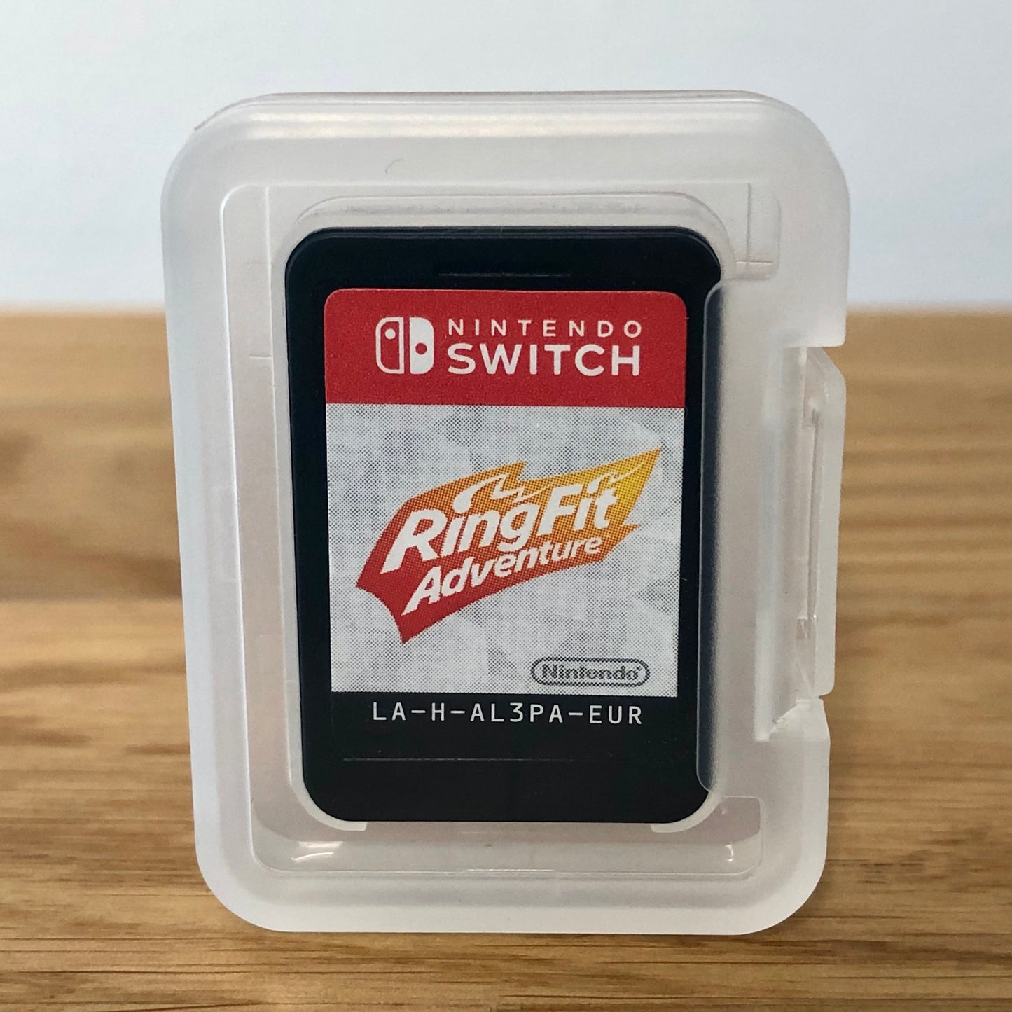 Cartridge of Ring fit adventure for Nintendo Switch, the cartridge is inside a cartridge size transparent protective case, through which you can see the front of the cartridge