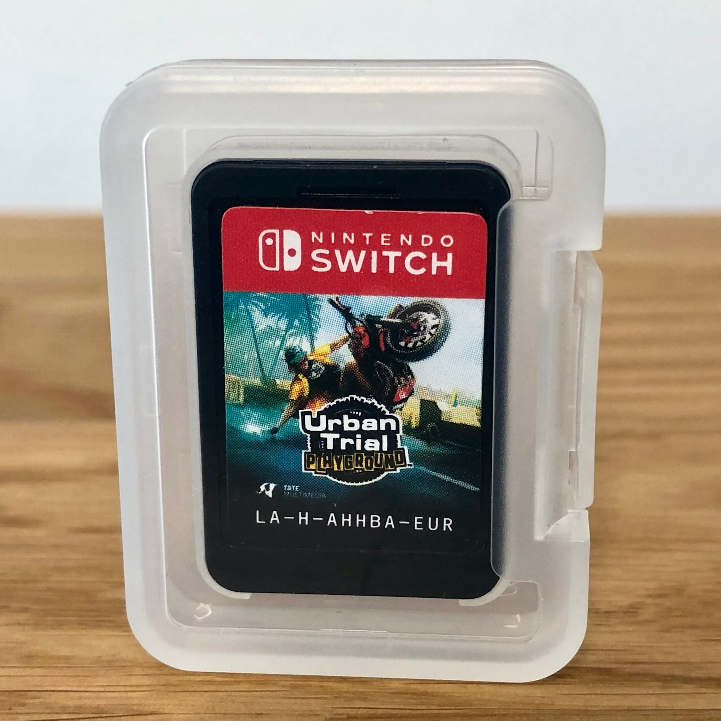 Cartridge of Urban Trial Playground for Nintendo Switch, the cartridge is inside a cartridge size transparent protective case, through which you can see the front of the cartridge