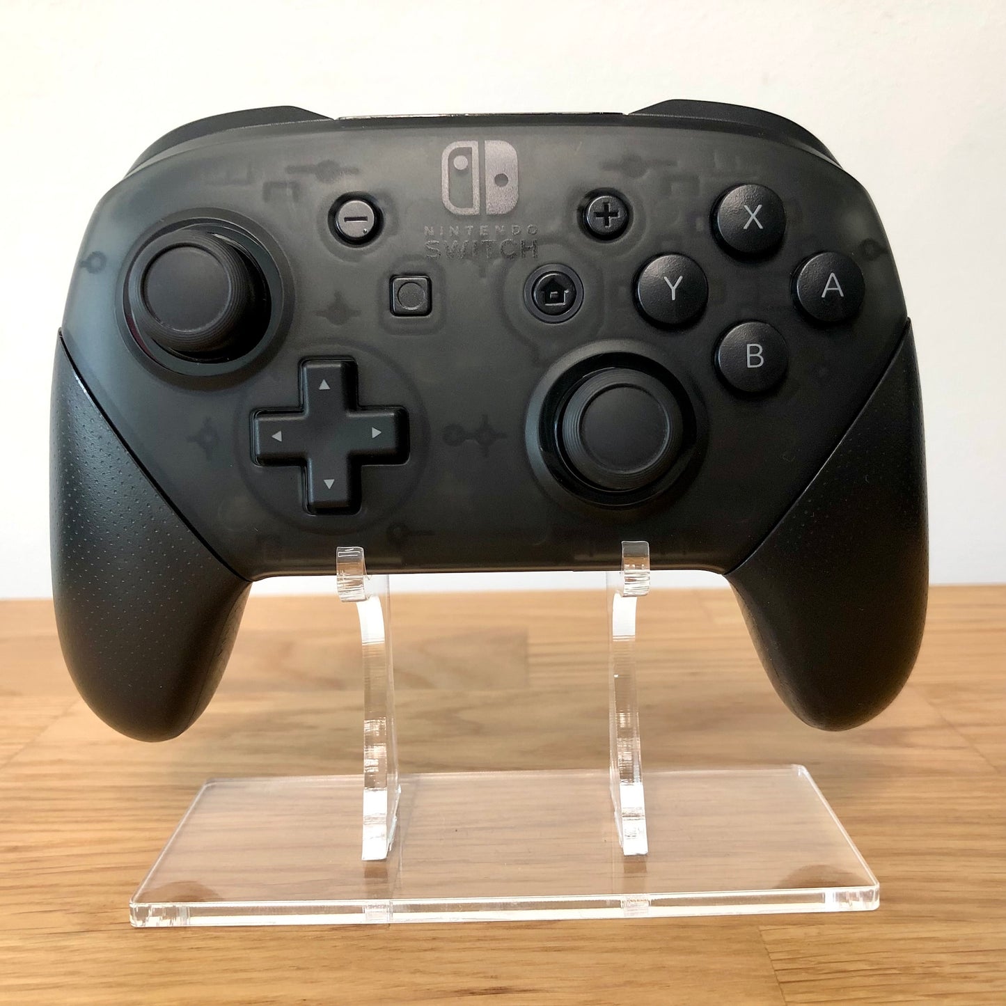 Front view of Nintendo Switch Pro Controller, showing button layout and ergonomic design.