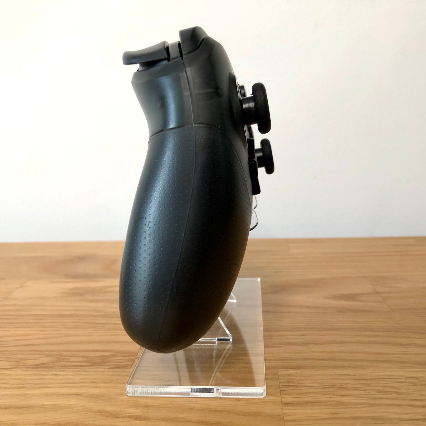 Side view of Nintendo Switch Pro Controller, showing button layout and ergonomic design.