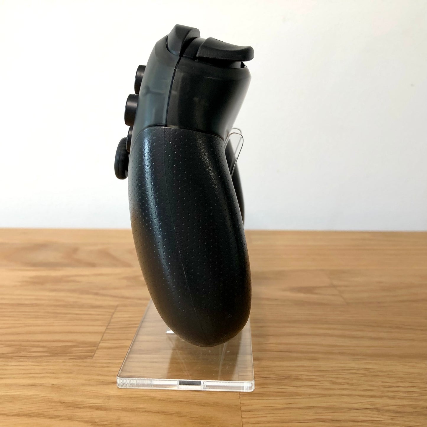 Side view of Nintendo Switch Pro Controller, showing button layout and ergonomic design.