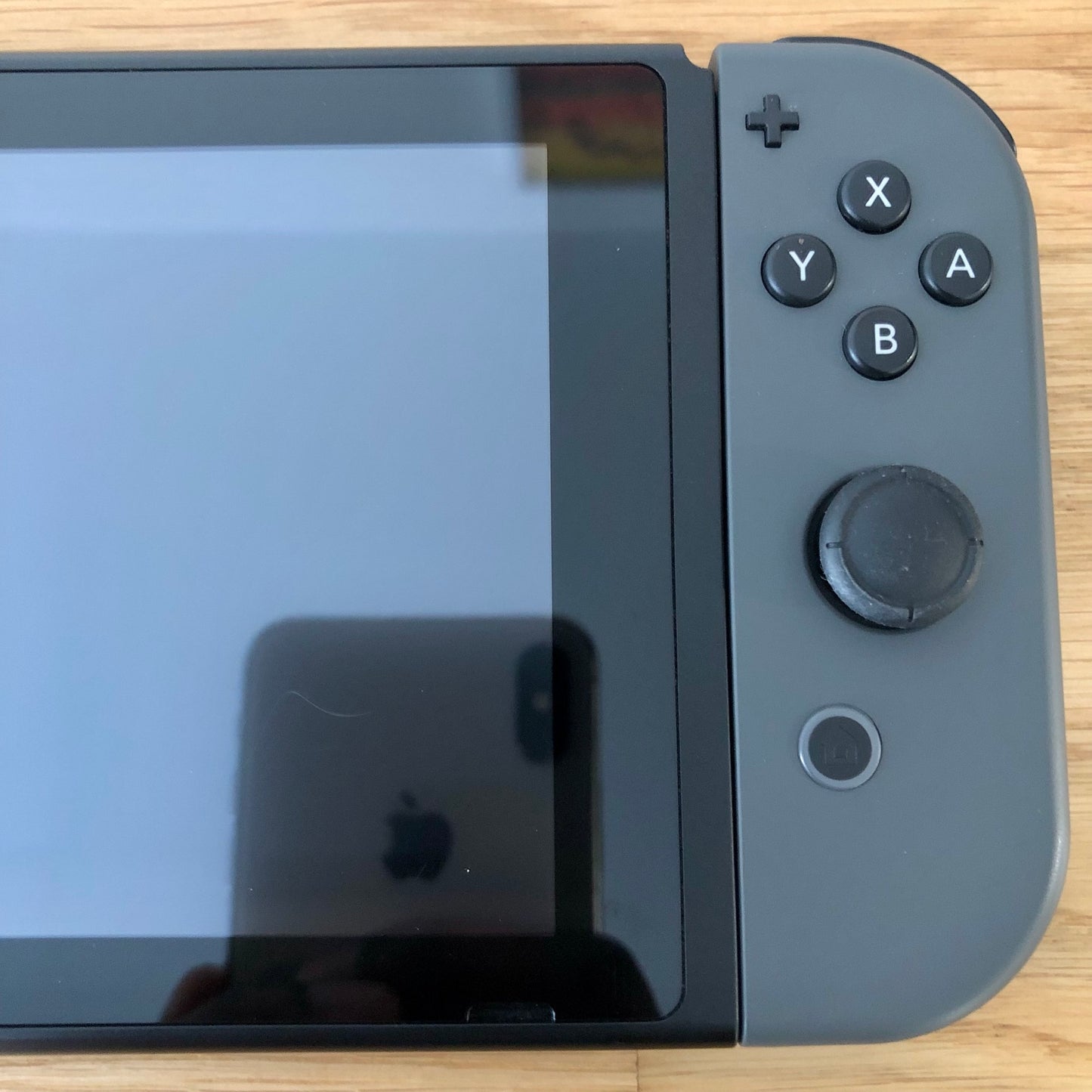 Close-up of grey right Joy-Con on Nintendo Switch, showing A, B, X, Y buttons, stick, plus and home button.