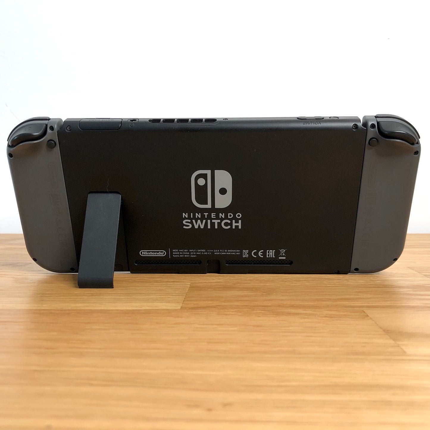 Rear of Nintendo Switch with kickstand open, showing logo, microSD card slot and part of the dock connector.