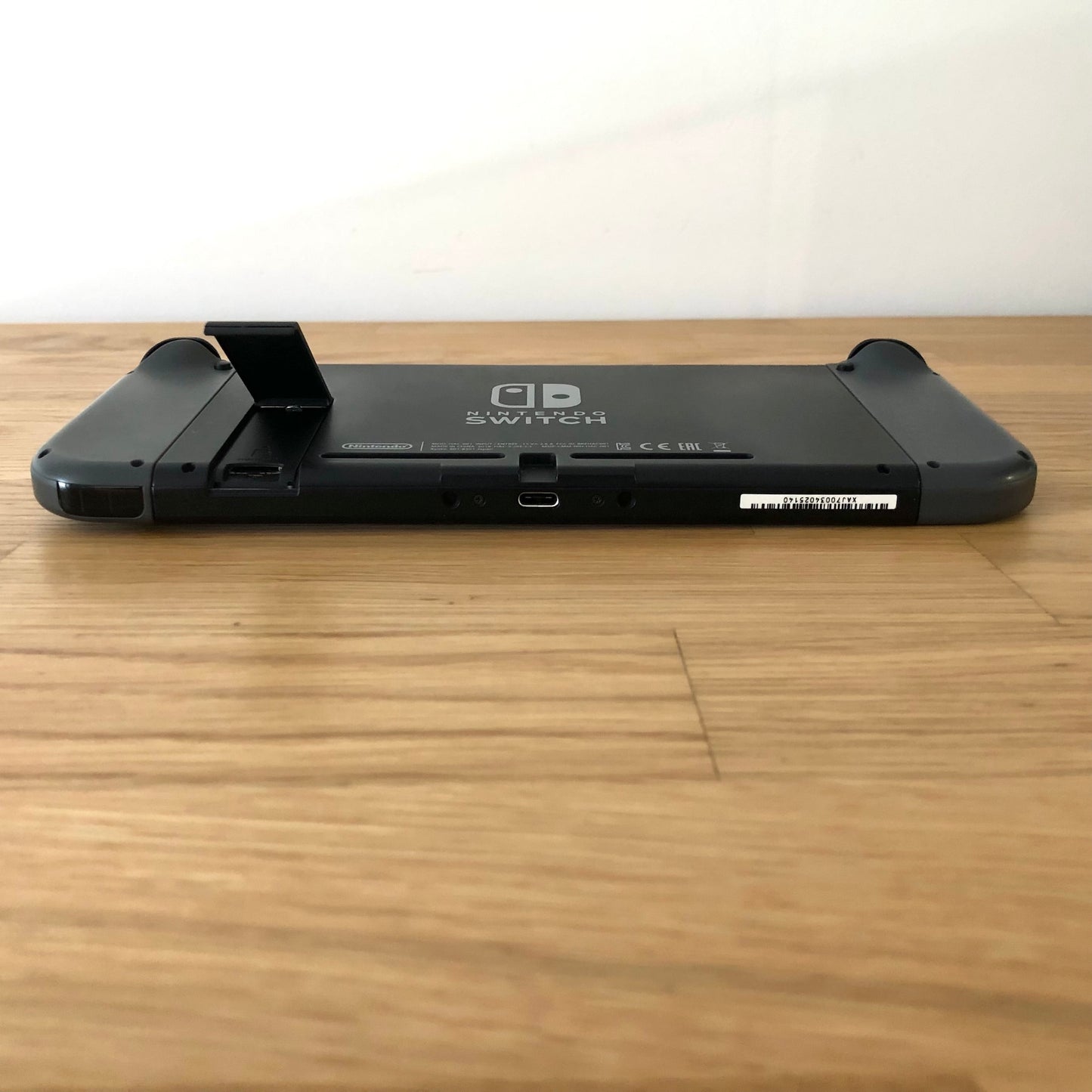 Rear of Nintendo Switch with kickstand open, showing logo, microSD card slot and part of the dock connector.