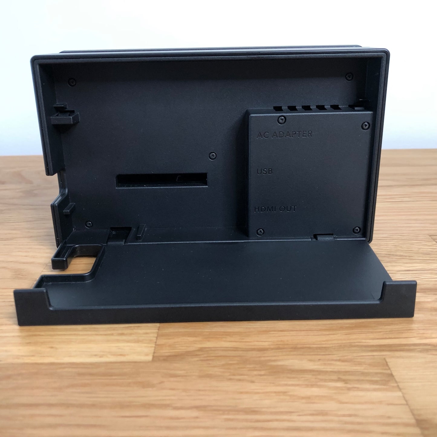 Inside of Nintendo Switch dock with flap open, showing ports for AC adapter, HDMI out and LAN.