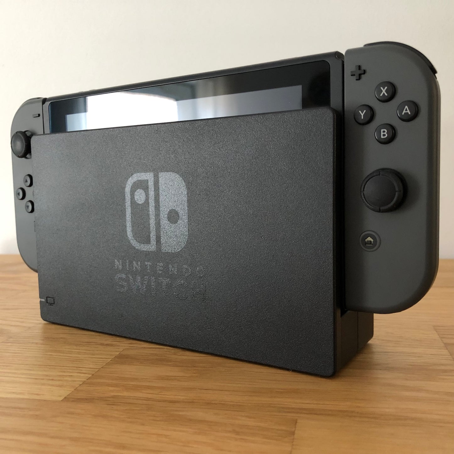 Angled view of grey Nintendo Switch console docked, showing control sticks and front buttons of Joy-Cons.