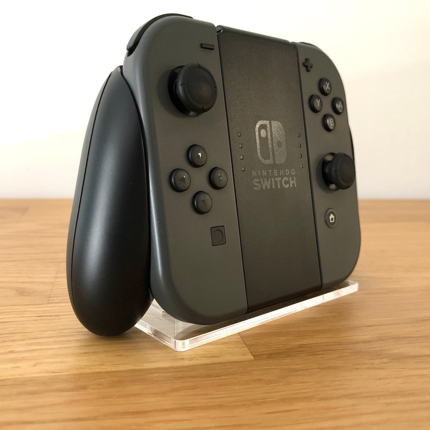 Angled left view of Joy-Con grip with grey Joy-Cons, showing all front facing buttons.