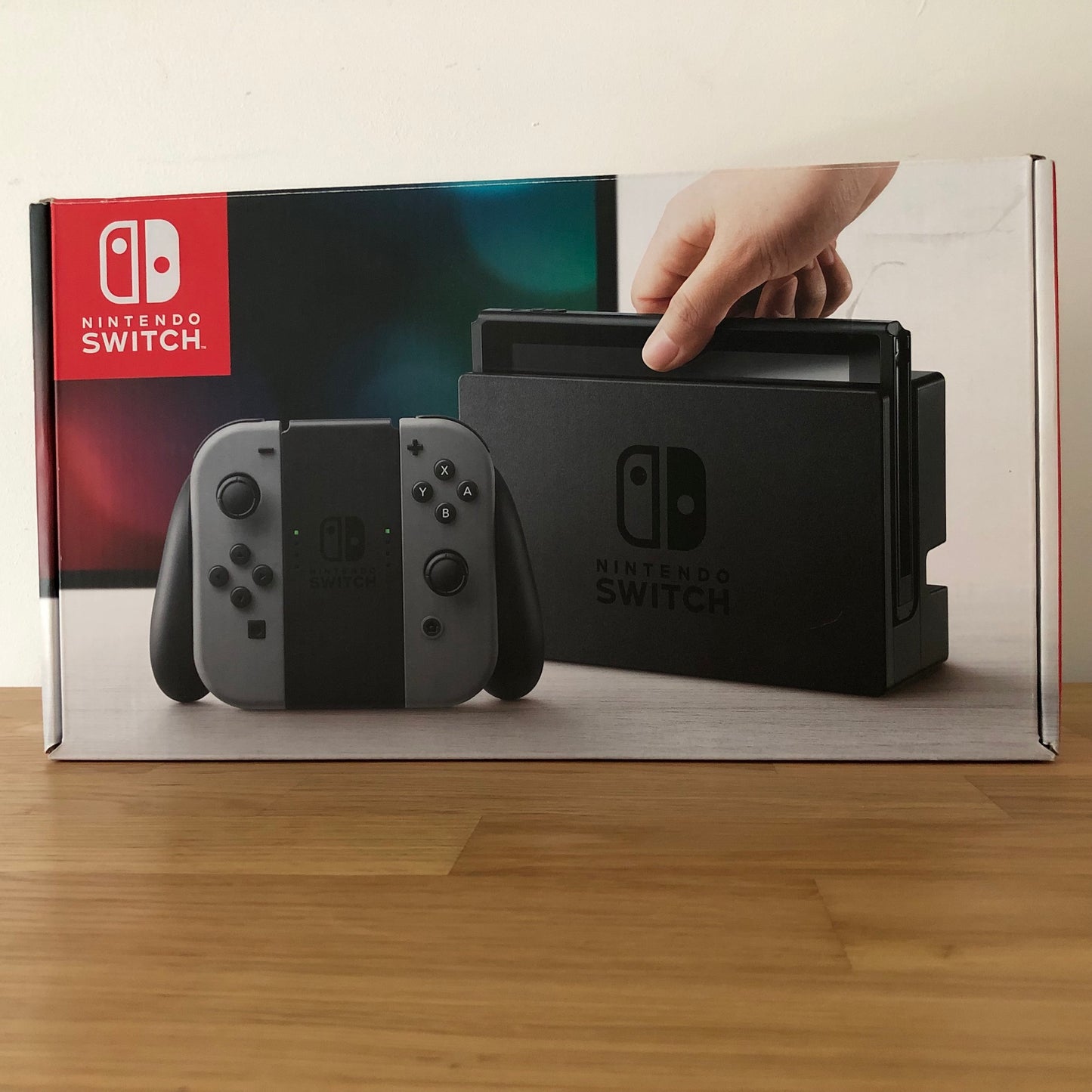 Front of Nintendo Switch box showing grey console and Joy-Cons, with screen artwork and red Nintendo branding.