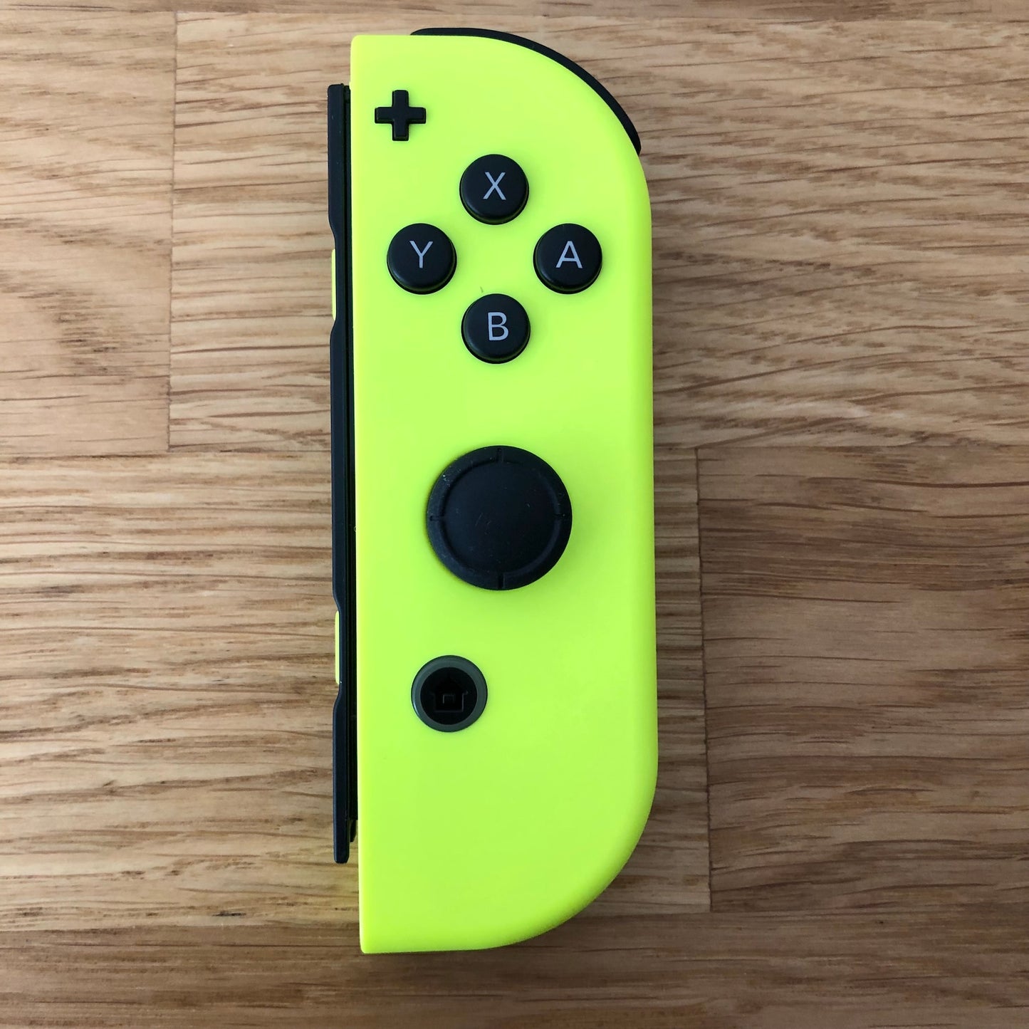 Top-down view of Neon Yellow Nintendo Switch Joy-Con controller with full button layout visible.