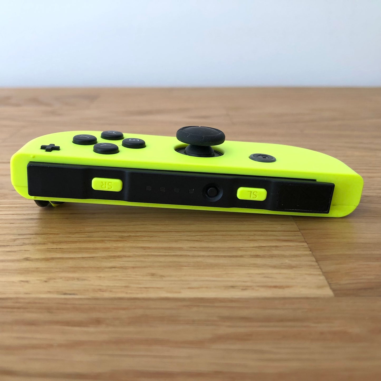 Bottom side view of Neon Yellow Nintendo Switch Joy-Con controller displaying SL, SR, and sync button.