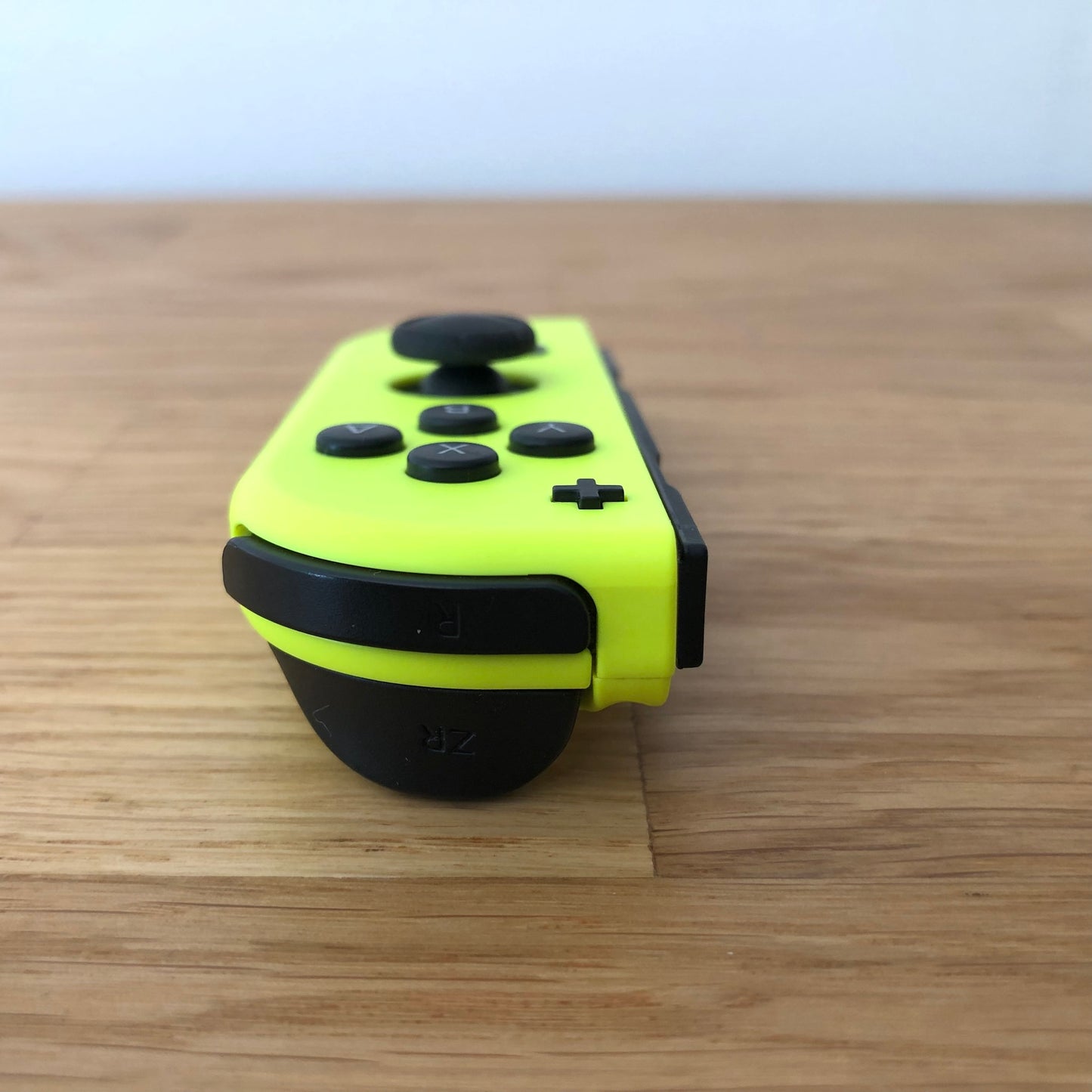 Angled front view of Neon Yellow Nintendo Switch Joy-Con controller showing shoulder buttons.