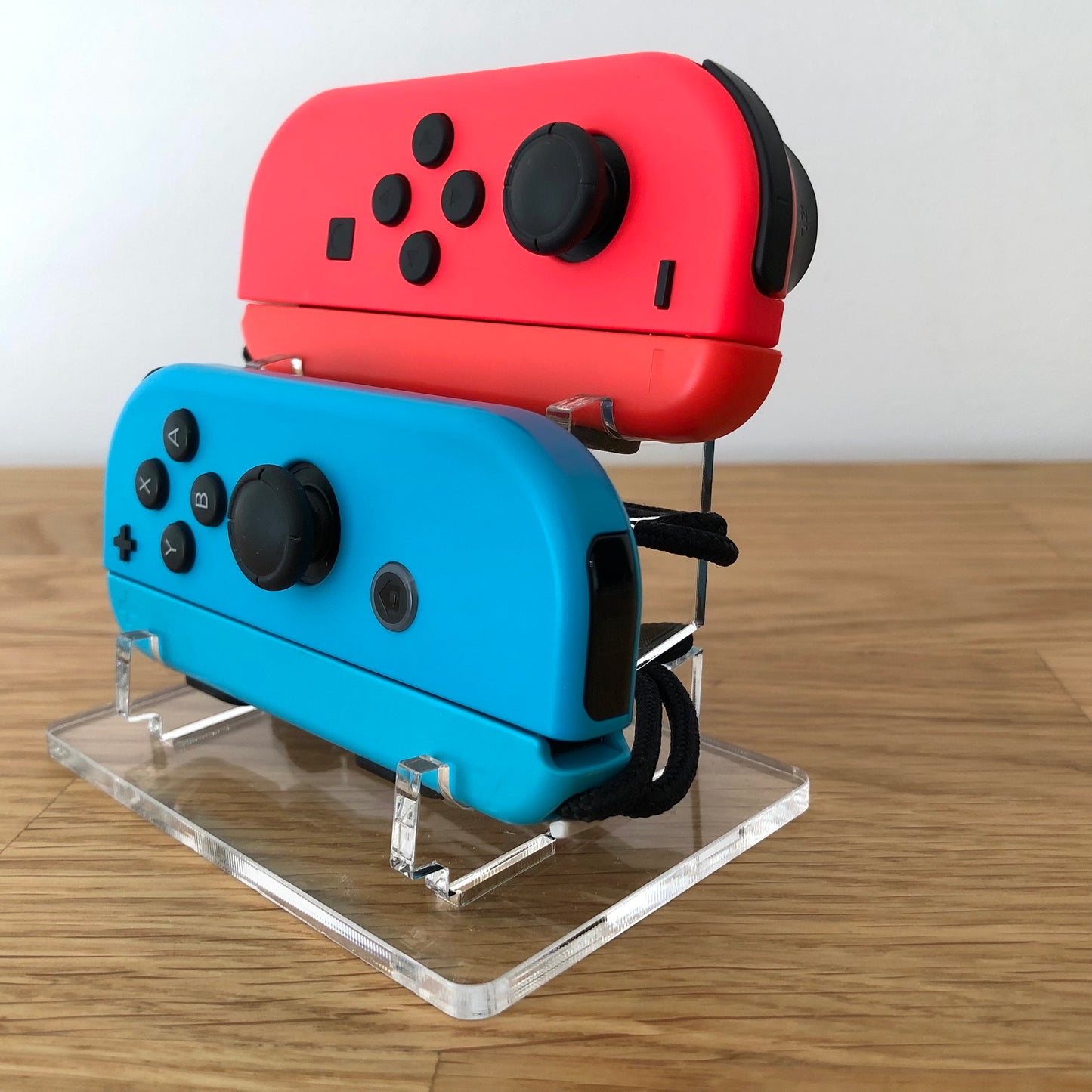 Angled rear view of neon red and blue Joy-Con controllers for Nintendo Switch, showing shoulder buttons.