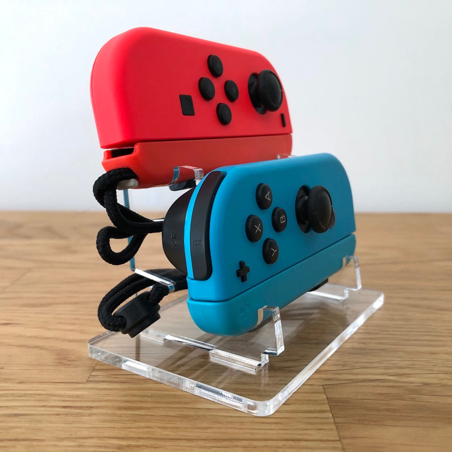 Angled rear view of neon red and blue Joy-Con controllers for Nintendo Switch, showing all buttons.