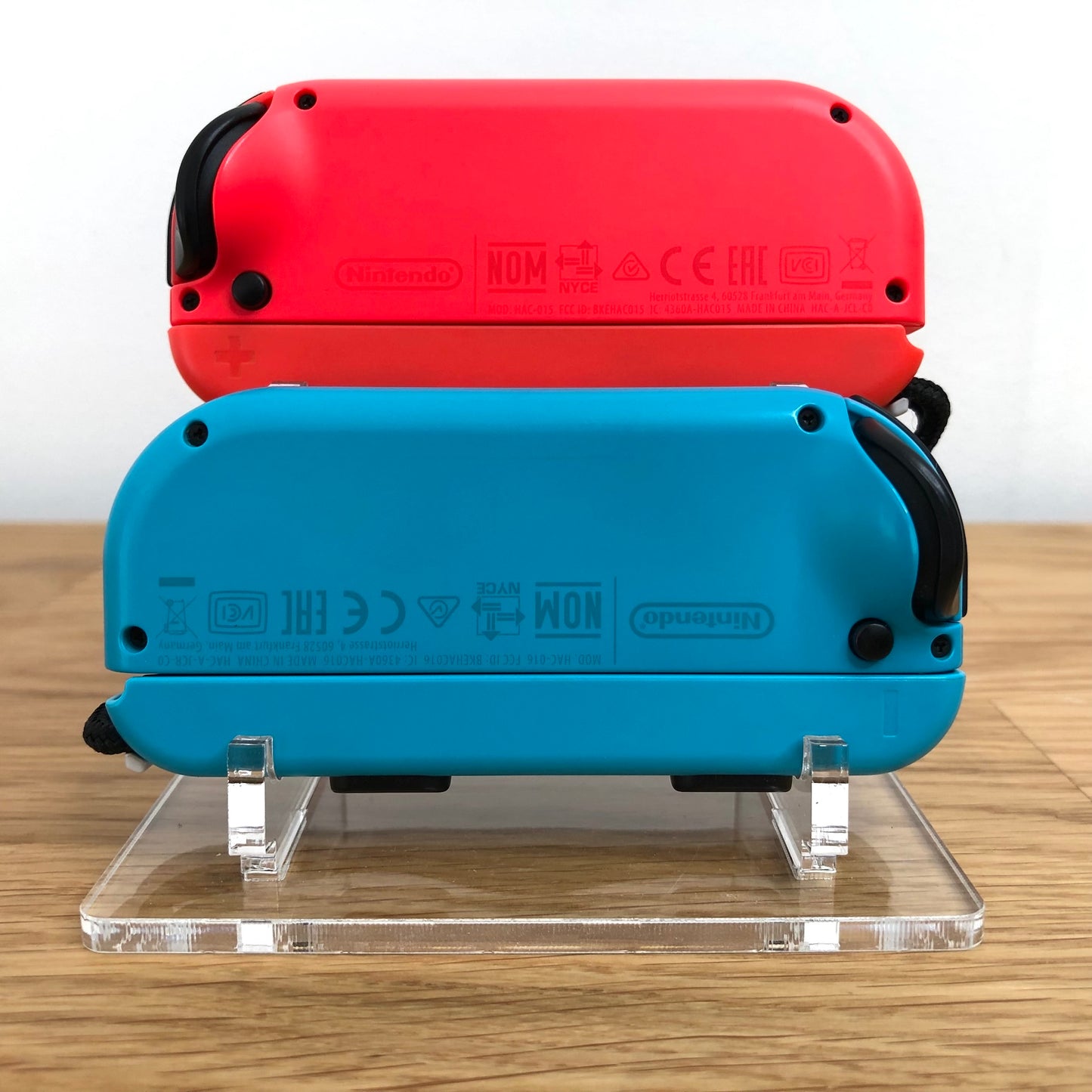 Back view of neon red and blue Nintendo Switch Joy-Con controllers, showing branding and serial details.