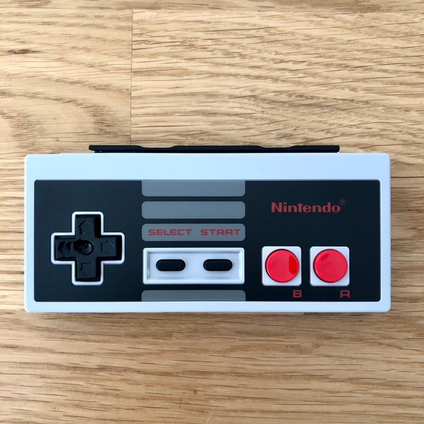 Birds eye view of Nintendo Switch NES Online Controller, showing button layout and design.