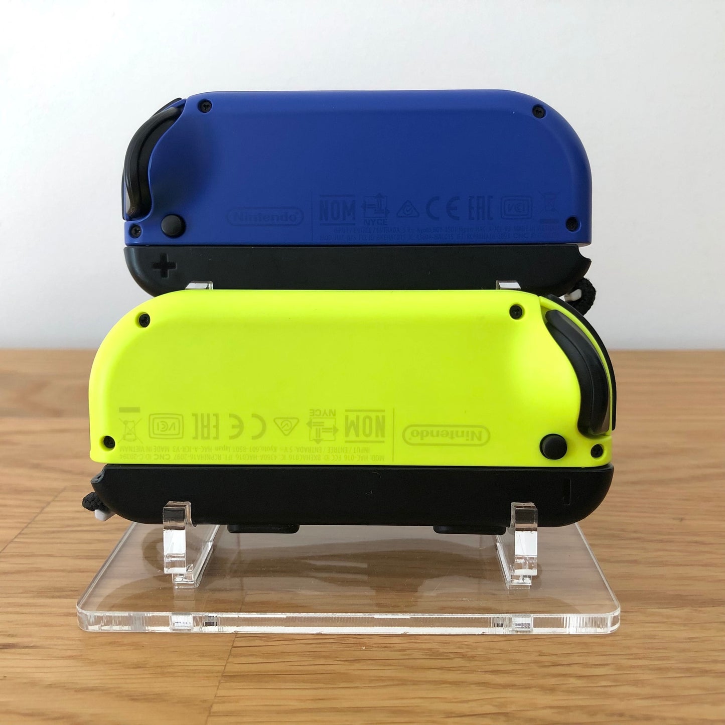 Back view of neon yellow and blue Nintendo Switch Joy-Con controllers with branding visible on both.