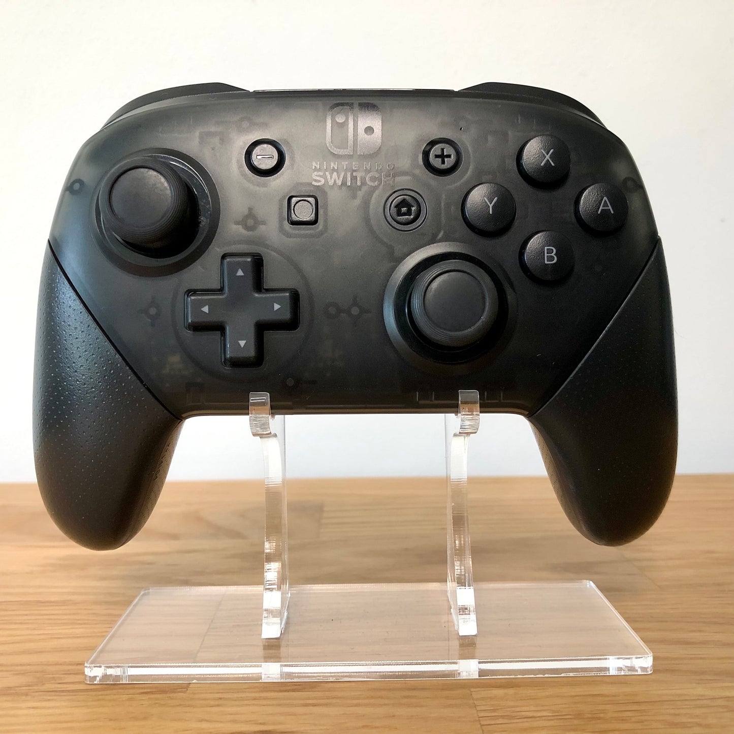 Front view of Nintendo Switch Pro Controller, showing button layout and ergonomic design.