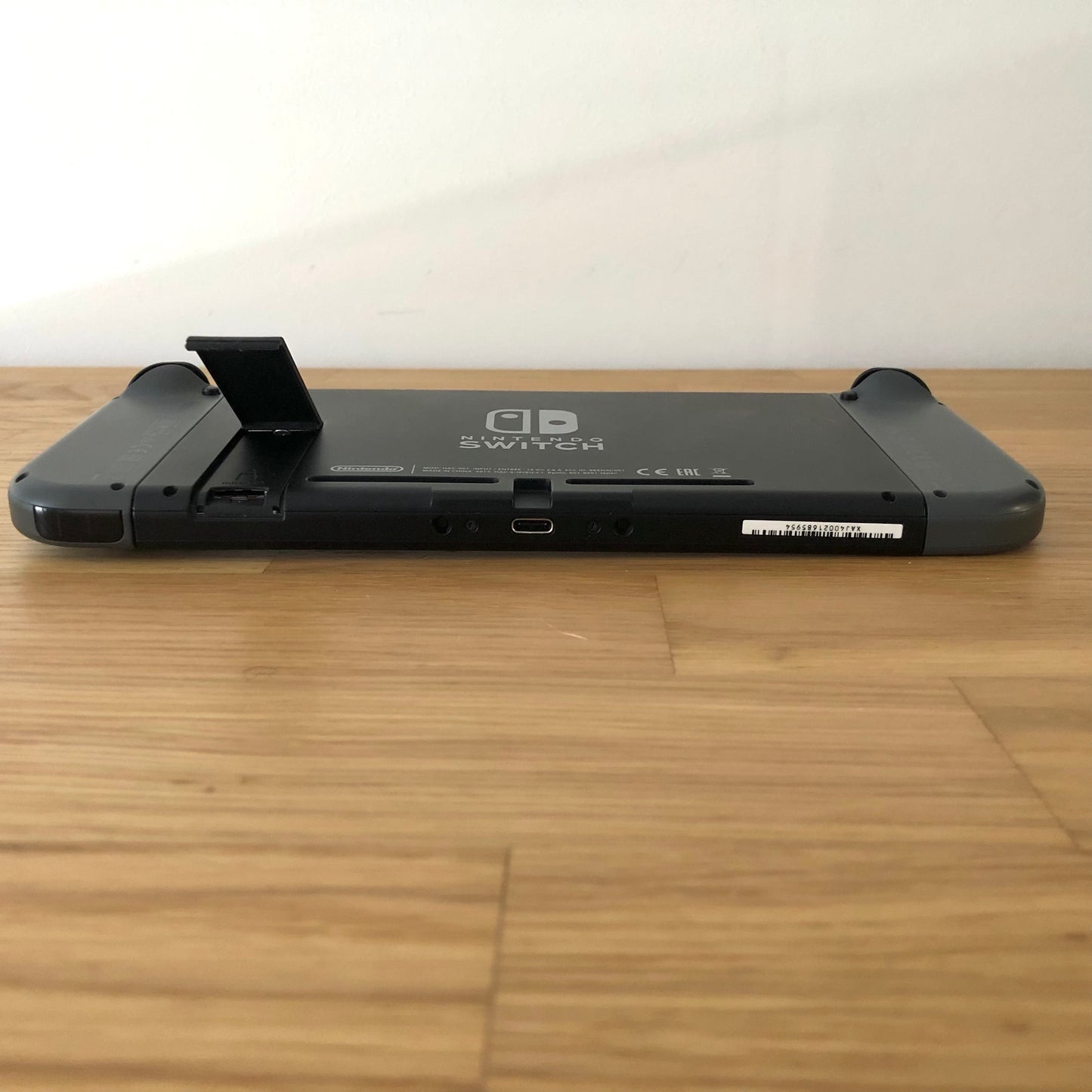 Rear of Nintendo Switch with kickstand open, showing logo, microSD card slot and part of the dock connector.