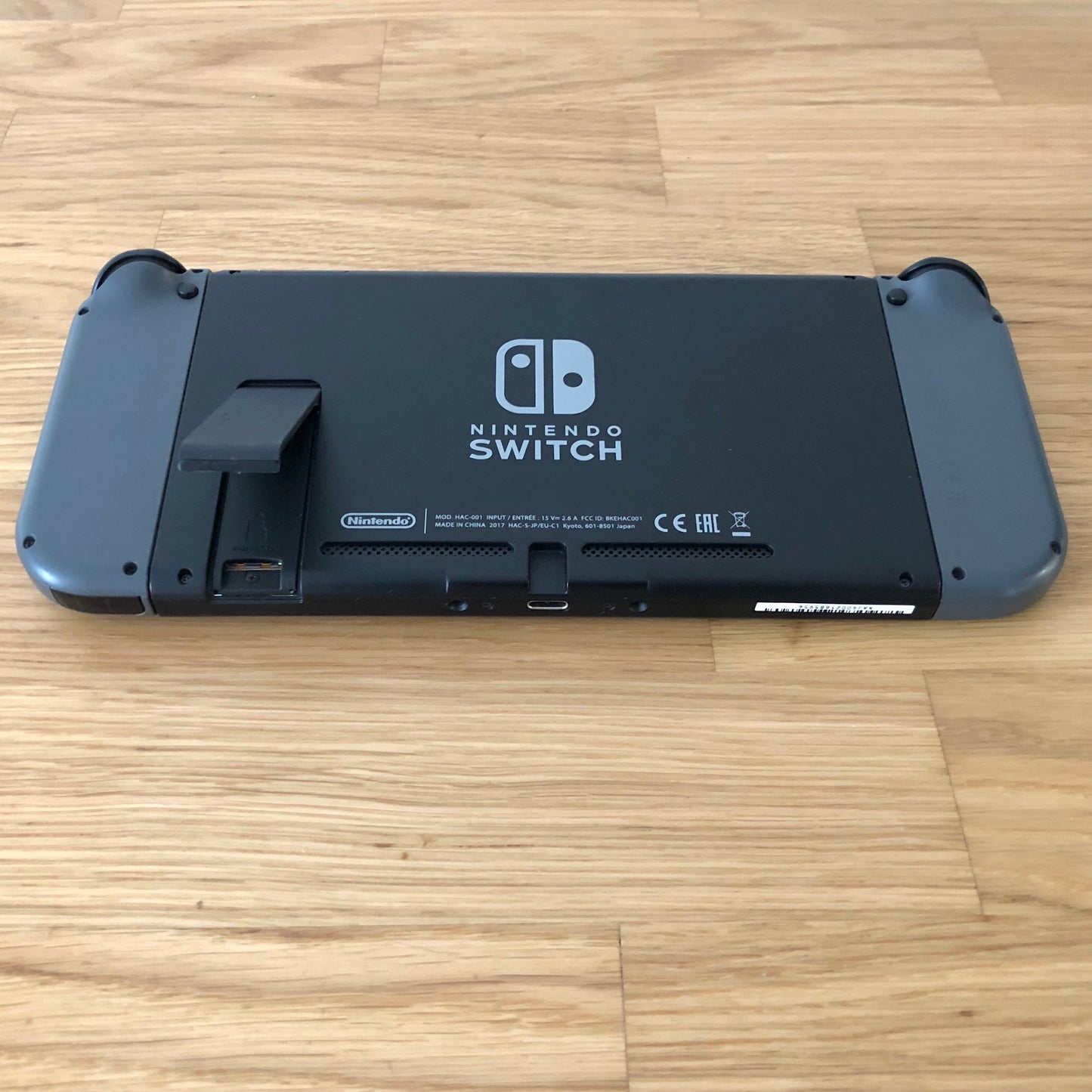 Rear of Nintendo Switch with kickstand open, showing logo, microSD card slot and part of the dock connector.