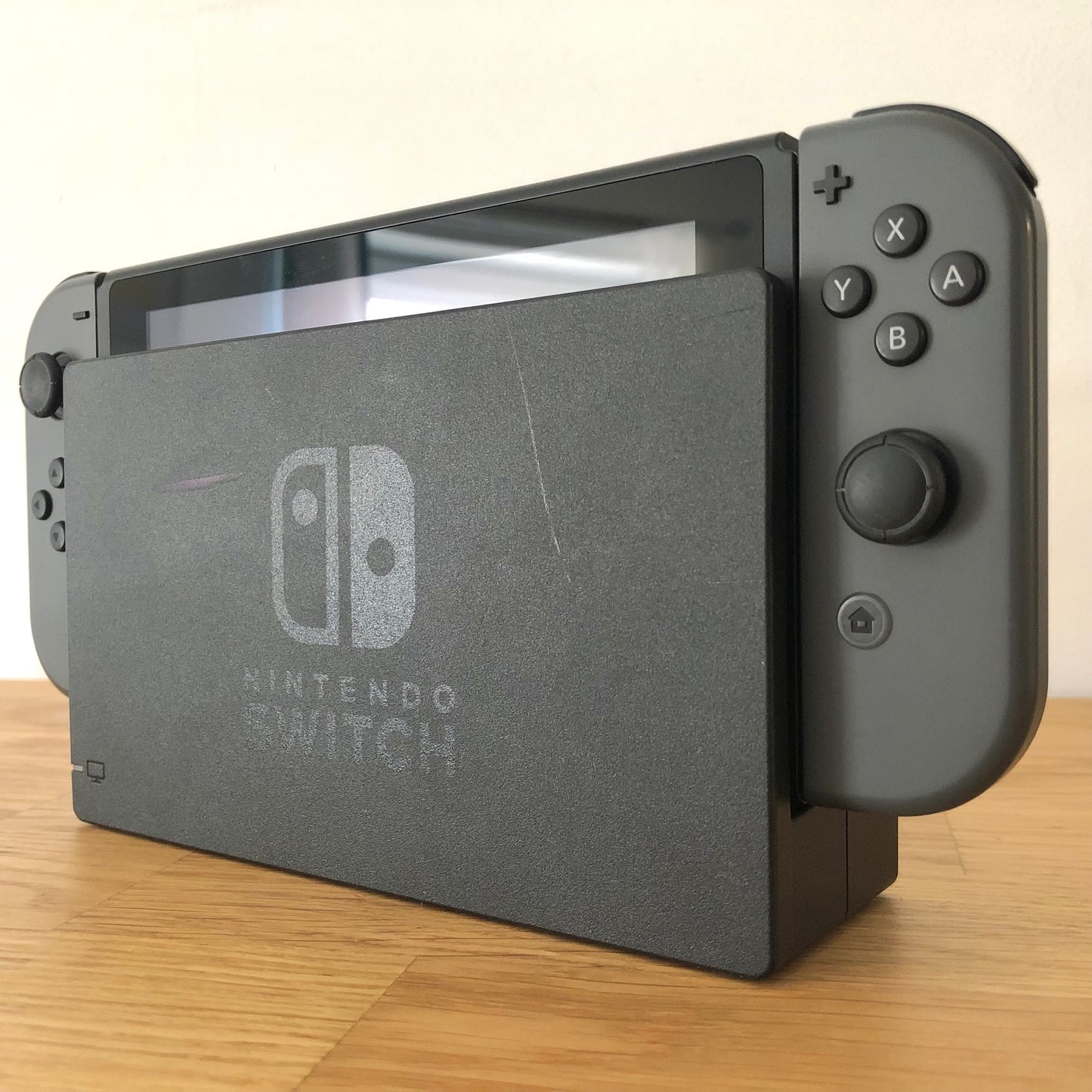 Angled right view of grey Nintendo Switch console docked, showing control sticks and front buttons of Joy-Cons.
