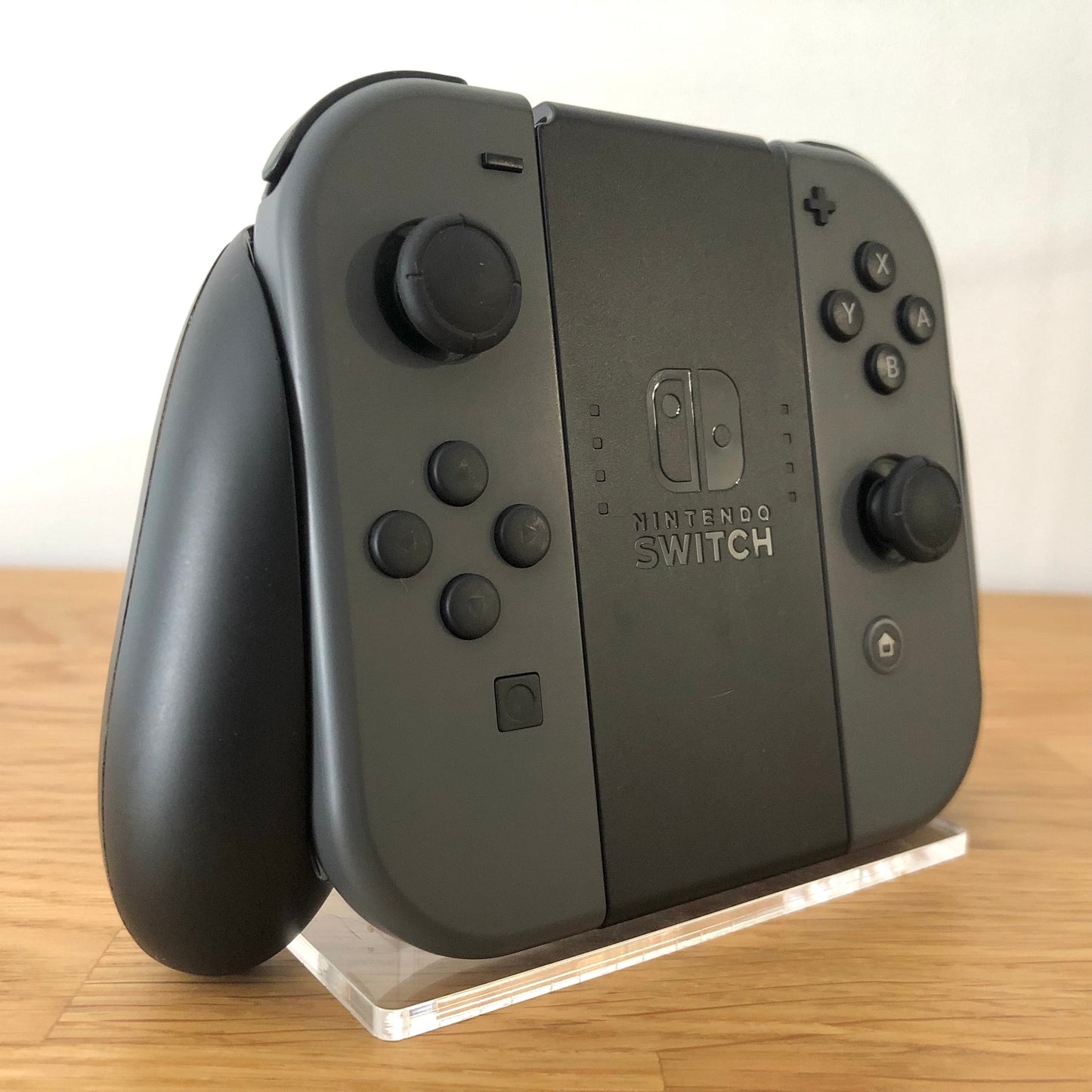 Angled left view of Joy-Con grip with grey Joy-Cons, showing all front facing buttons.
