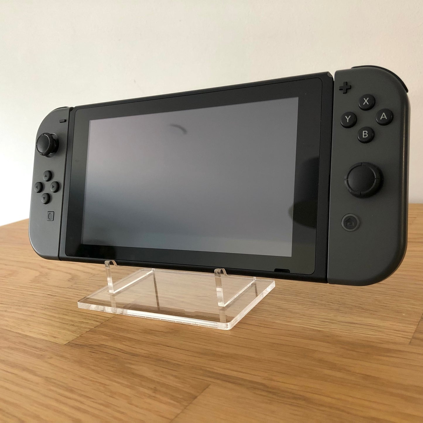 Front view of Nintendo Switch console with grey Joy-Cons attached, showing screen and face button layout.