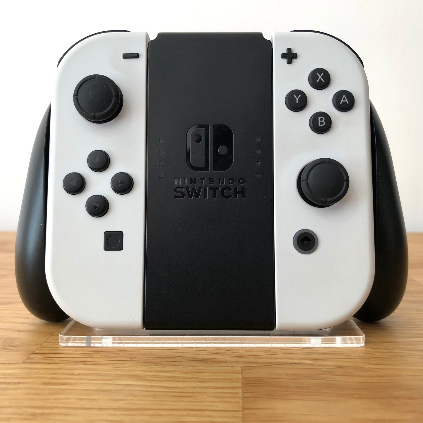 Front view of Joy-Con grips for Nintendo Switch with white Joy-Cons attached, showing condition with all face buttons visible.