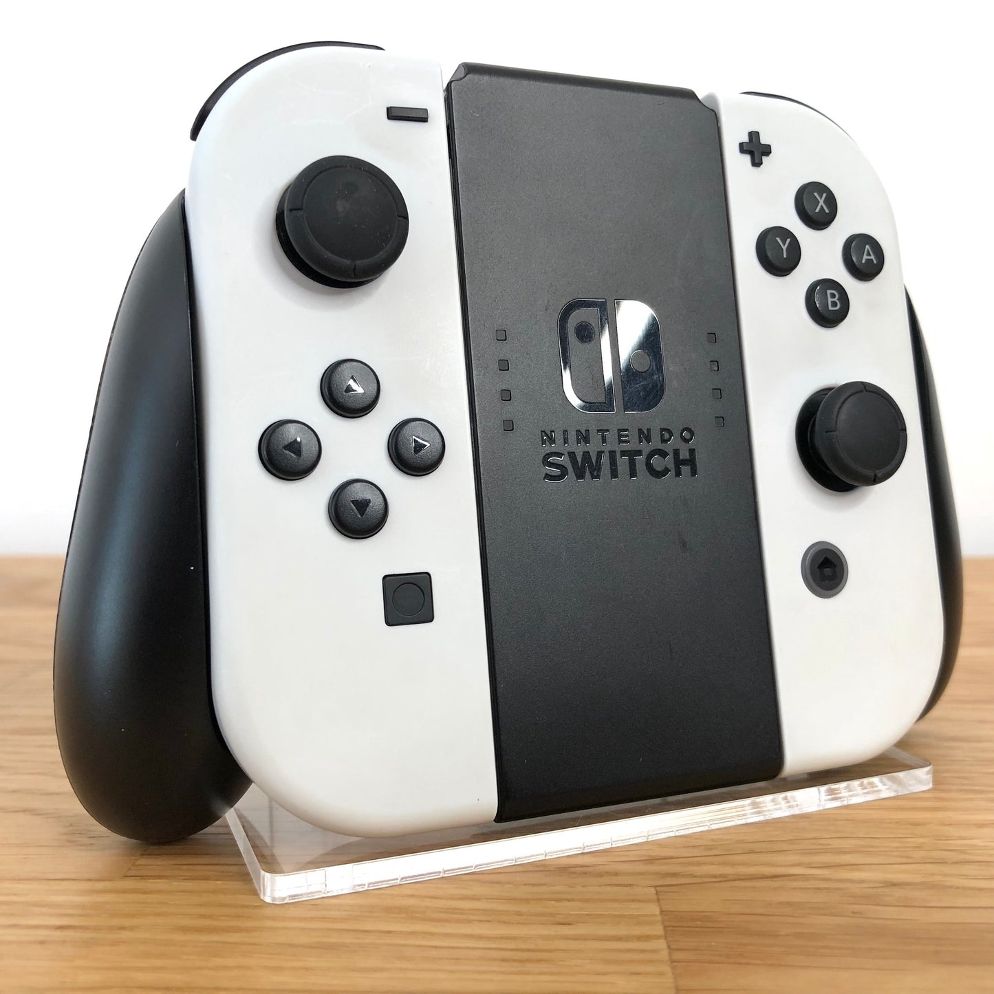 Angled view of Joy-Con grips for Nintendo Switch with white Joy-Cons attached, showing condition with all face buttons visible.
