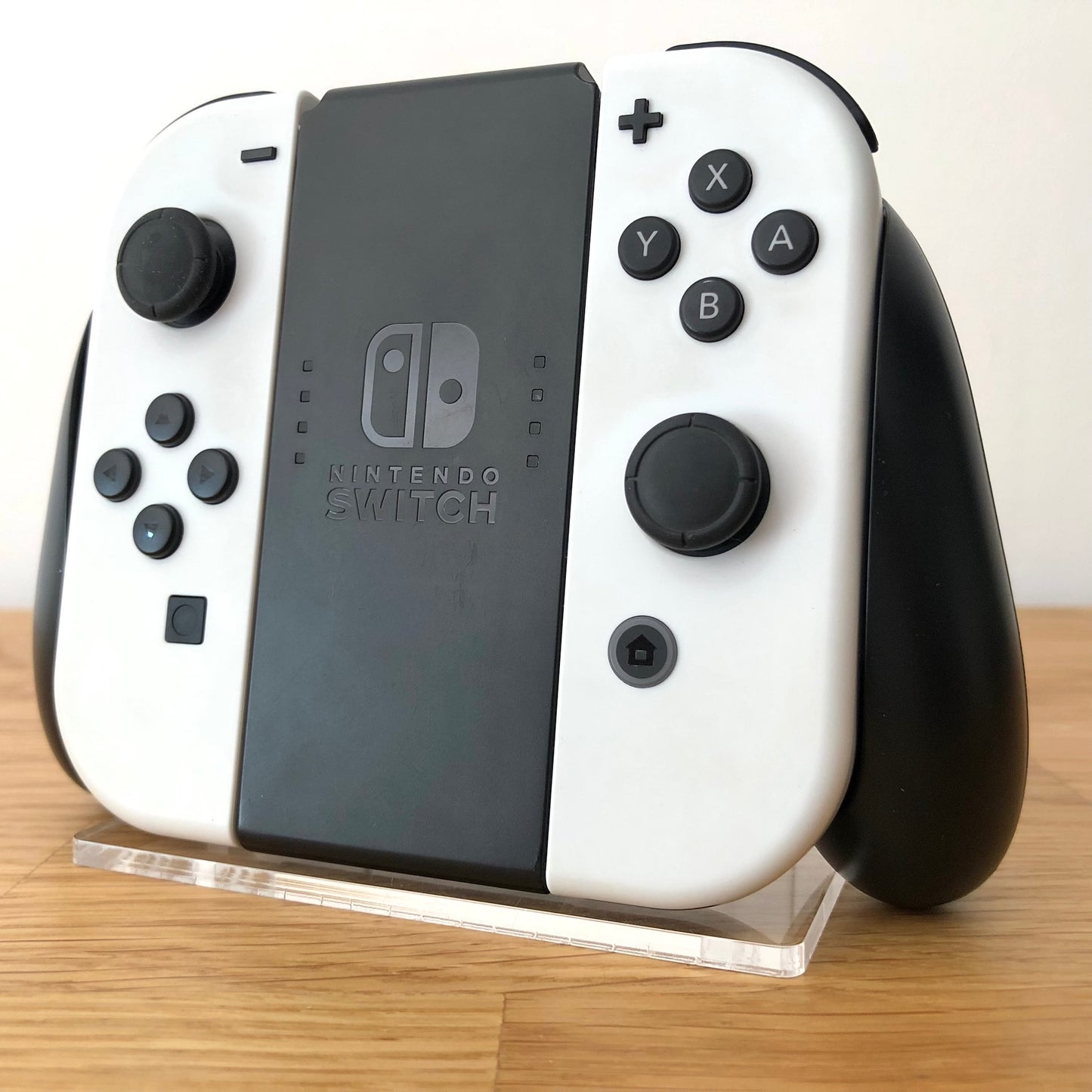 Angled view of Joy-Con grips for Nintendo Switch with white Joy-Cons attached, showing condition with all face buttons visible.
