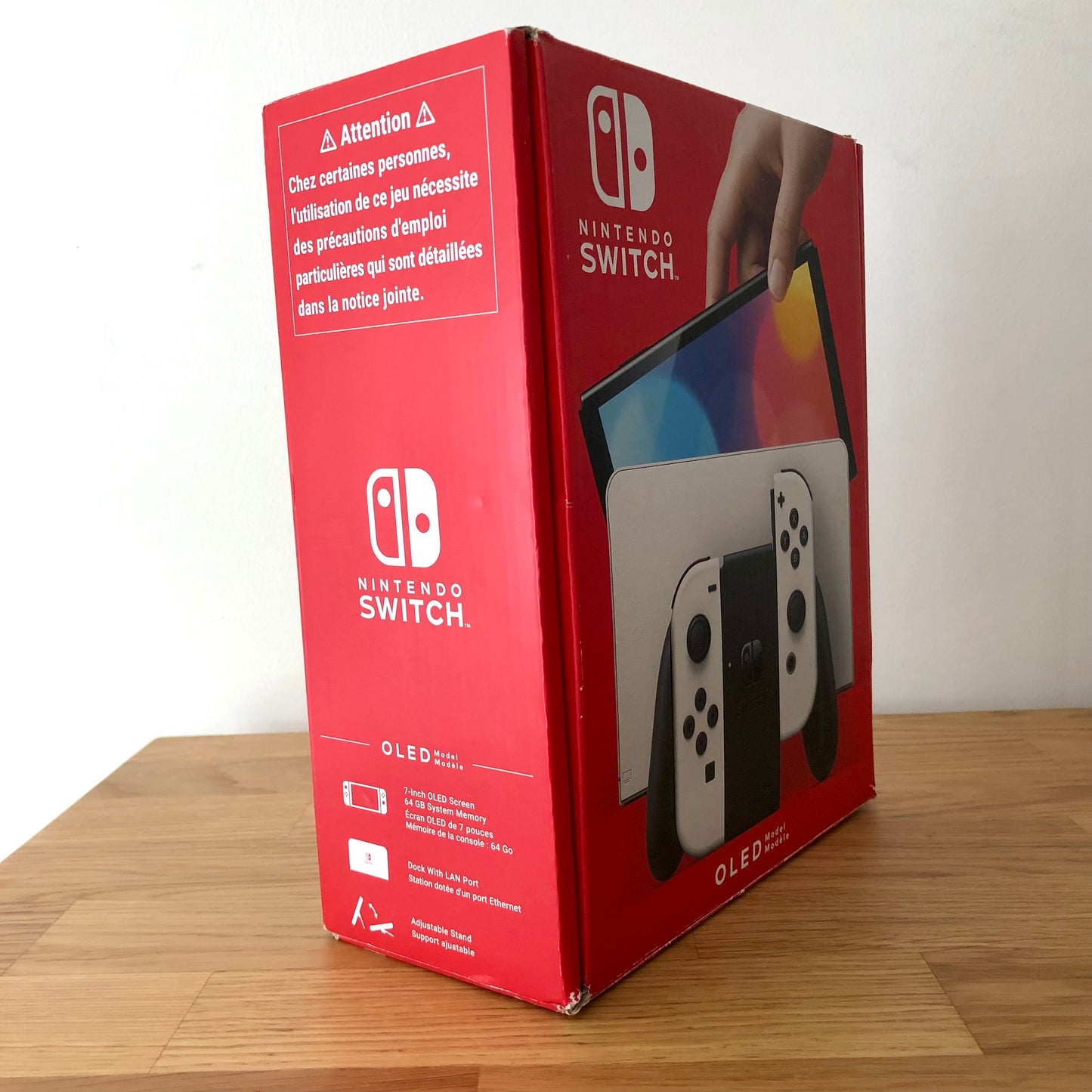 Side angle of Nintendo Switch OLED box showing features, branding, and product details in English and French.