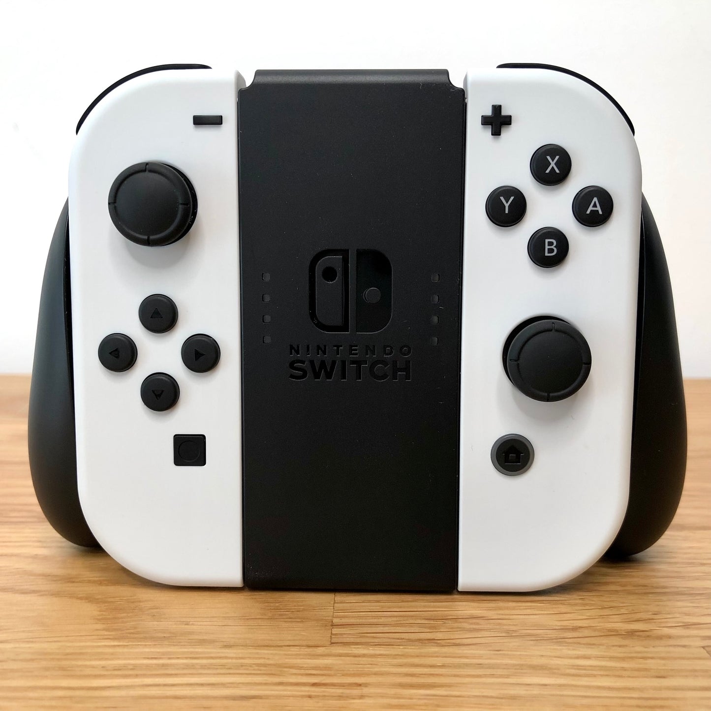 Front view of Joy-Con grips for Nintendo Switch with white Joy-Cons attached, showing condition with all face buttons visible.