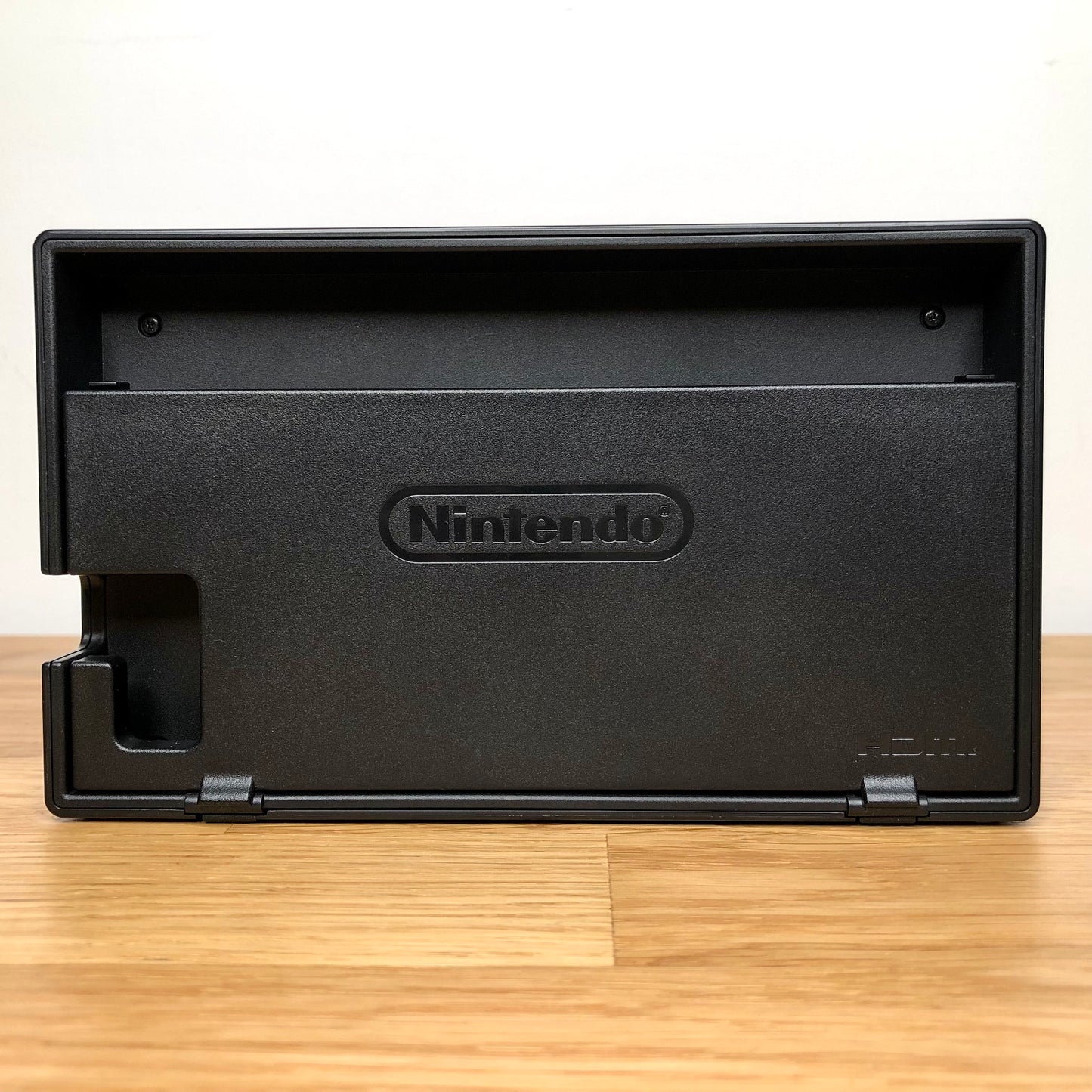 Rear of grey Nintendo Switch dock with HDMI branding and Nintendo logo, cable slot openings on left side.
