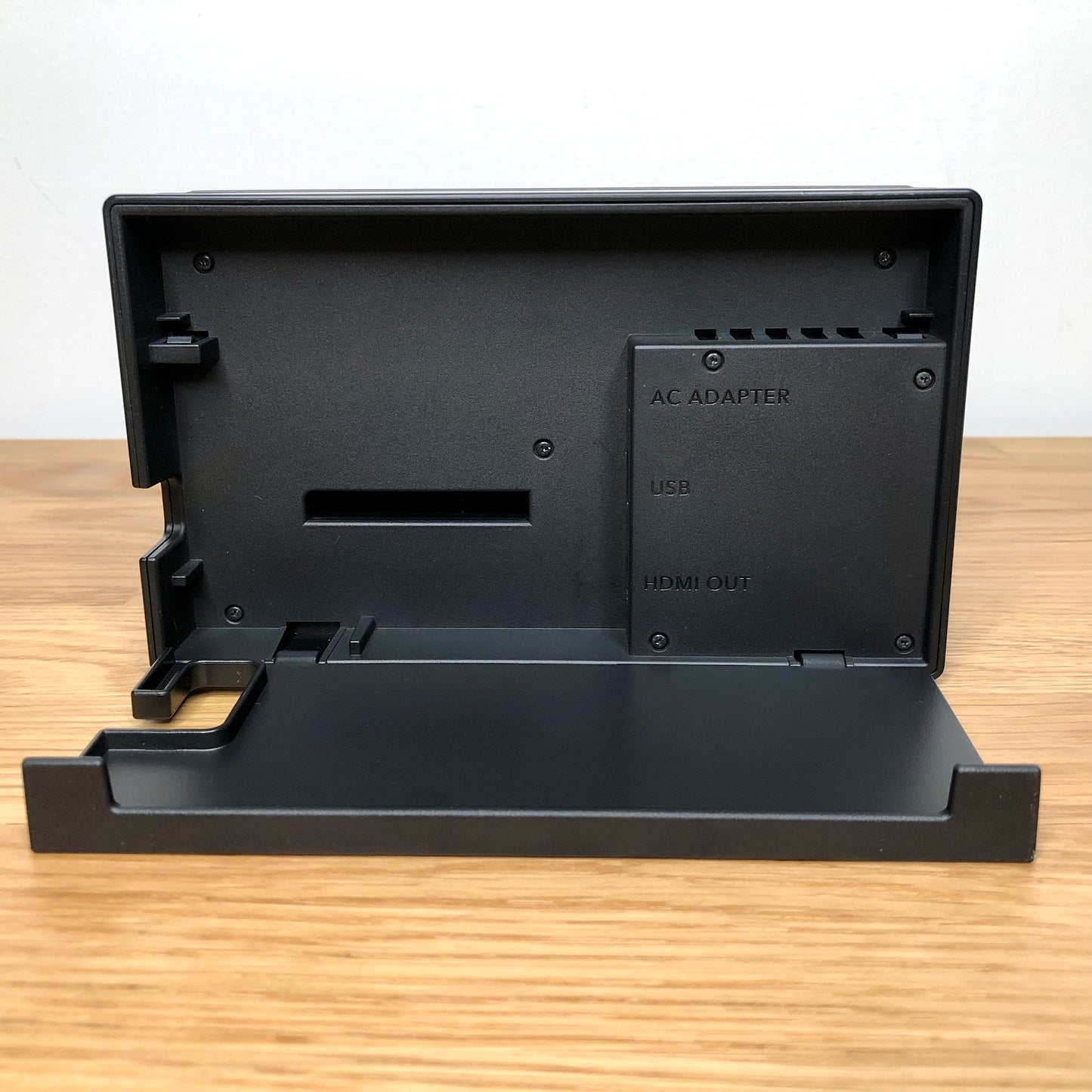 Inside of grey Nintendo Switch dock with flap open, showing ports for AC adapter, HDMI out and LAN.