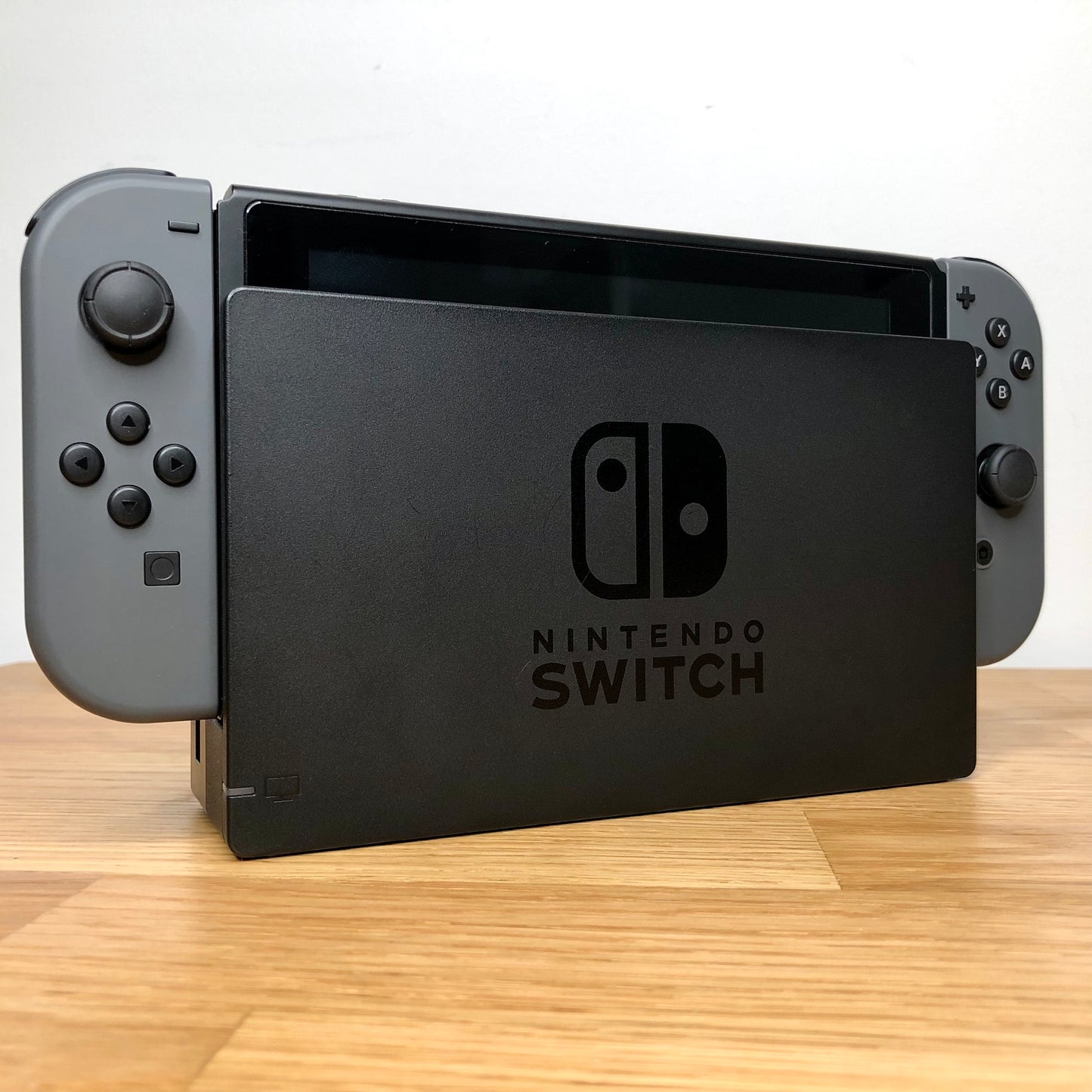 Angled view of grey Nintendo Switch console docked, showing control sticks and front buttons of Joy-Cons.