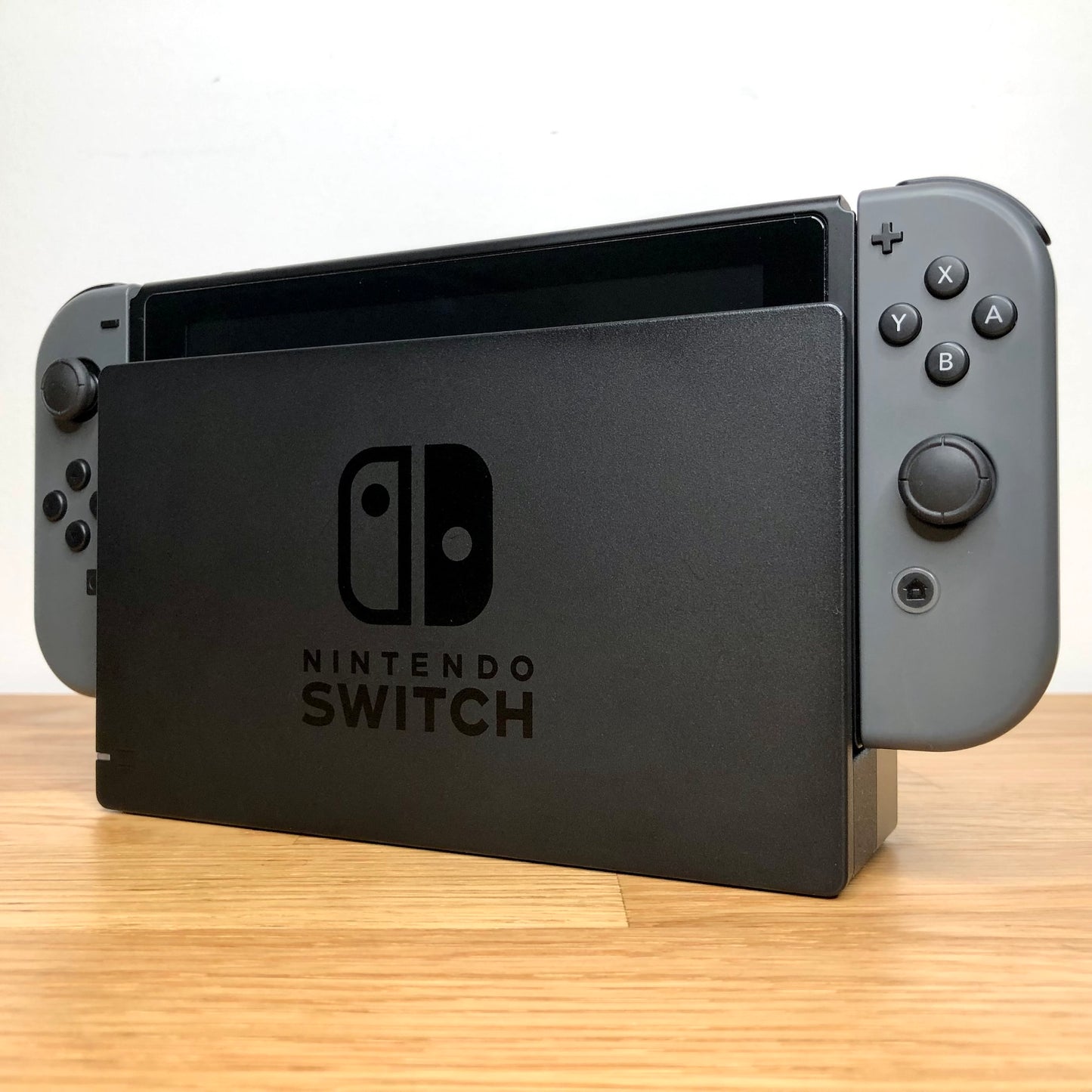 Angled view of grey Nintendo Switch console docked, showing control sticks and front buttons of Joy-Cons.