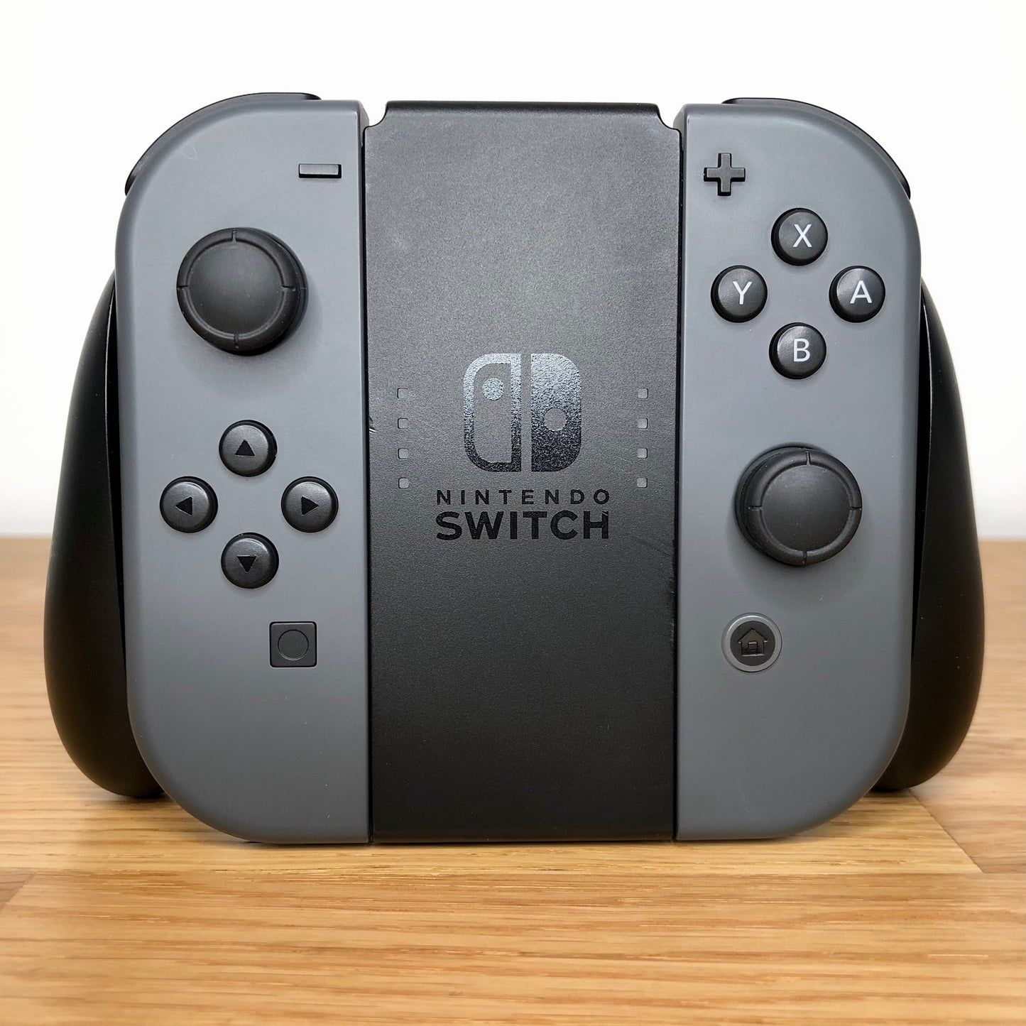 Front view of Joy-Con grip with grey Nintendo Switch Joy-Cons, showing all face buttons.