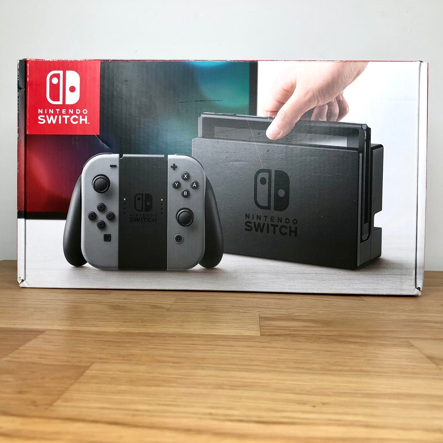 Front of Nintendo Switch box showing grey console and Joy-Cons, with screen artwork and red Nintendo branding.