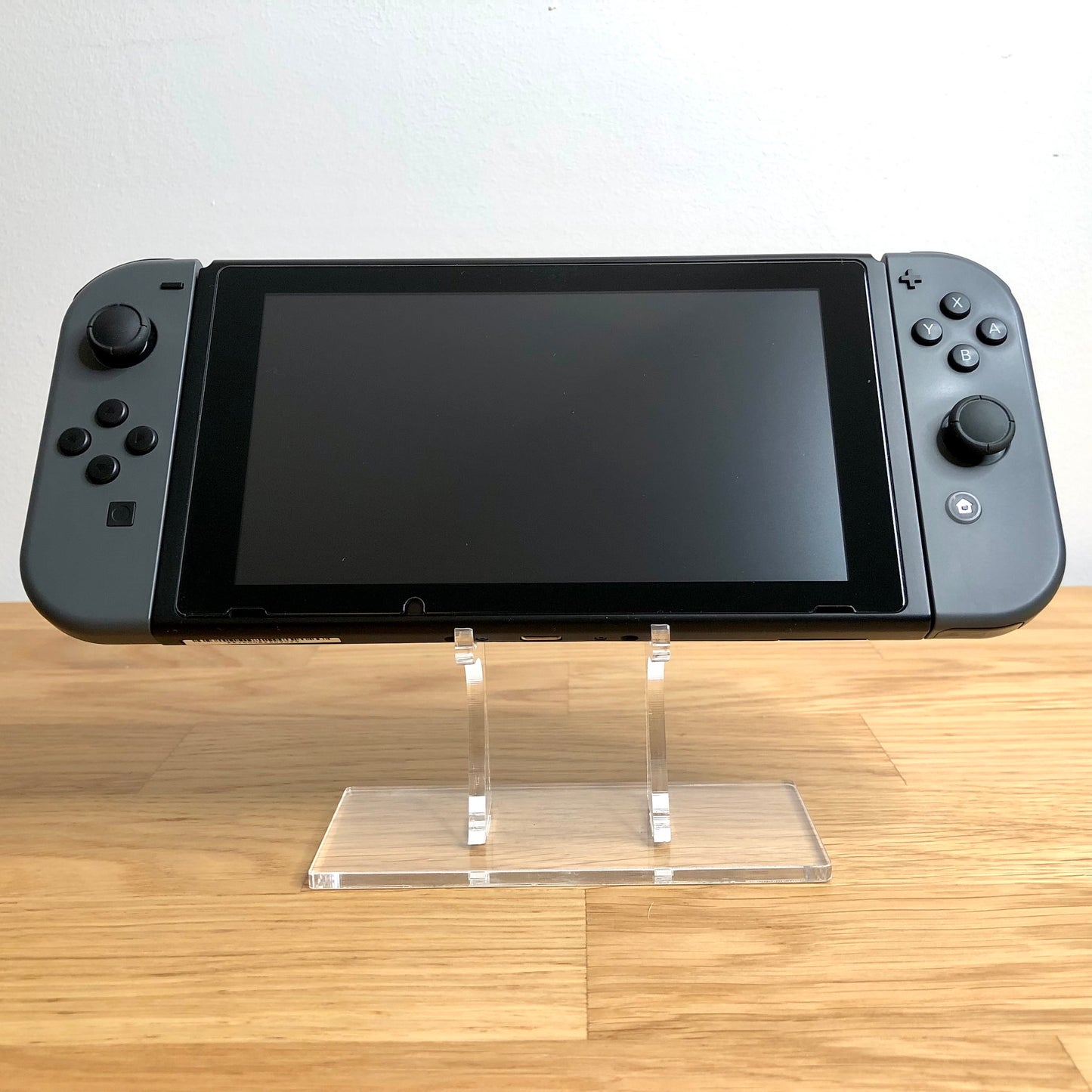 Front view of Nintendo Switch console with grey Joy-Cons attached, showing screen and face button layout.
