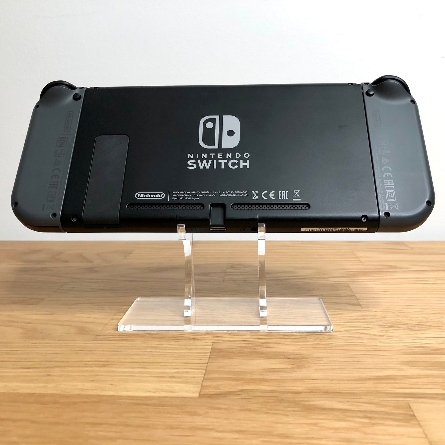 Back of Nintendo Switch console with Joy-Cons attached, showing logo, serial info, triggers and kickstand.