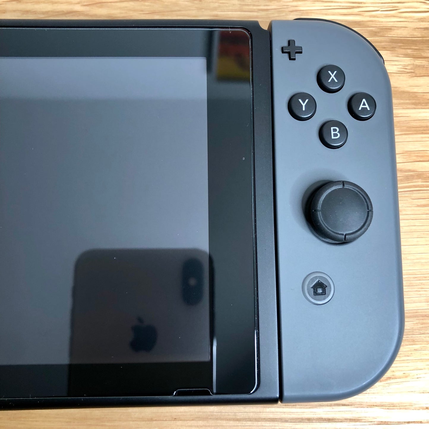 Close-up of grey right Joy-Con on Nintendo Switch, showing A, B, X, Y buttons, stick, plus and home button.