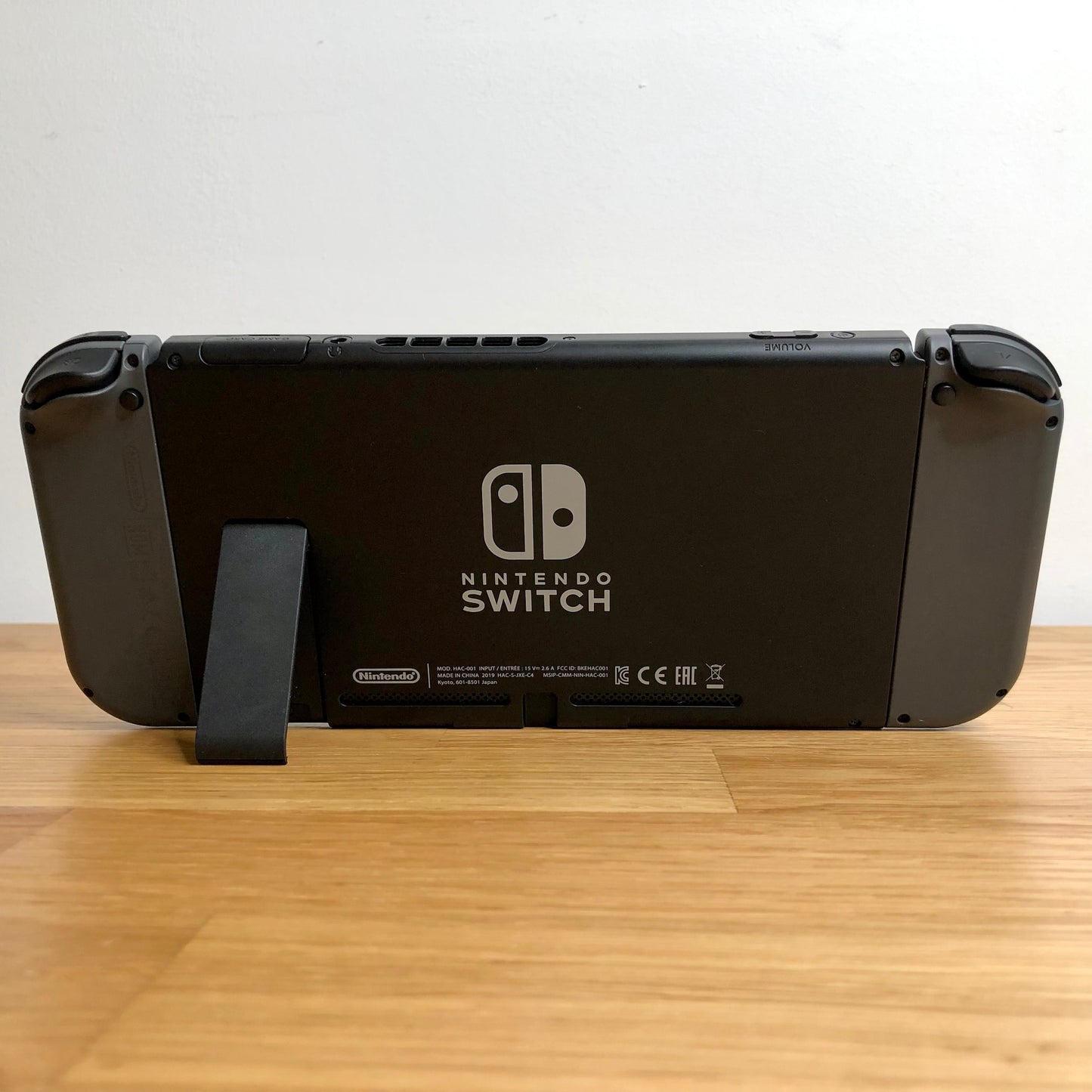 Back of Nintendo Switch console with Joy-Cons attached, showing logo, serial info, triggers and kickstand.