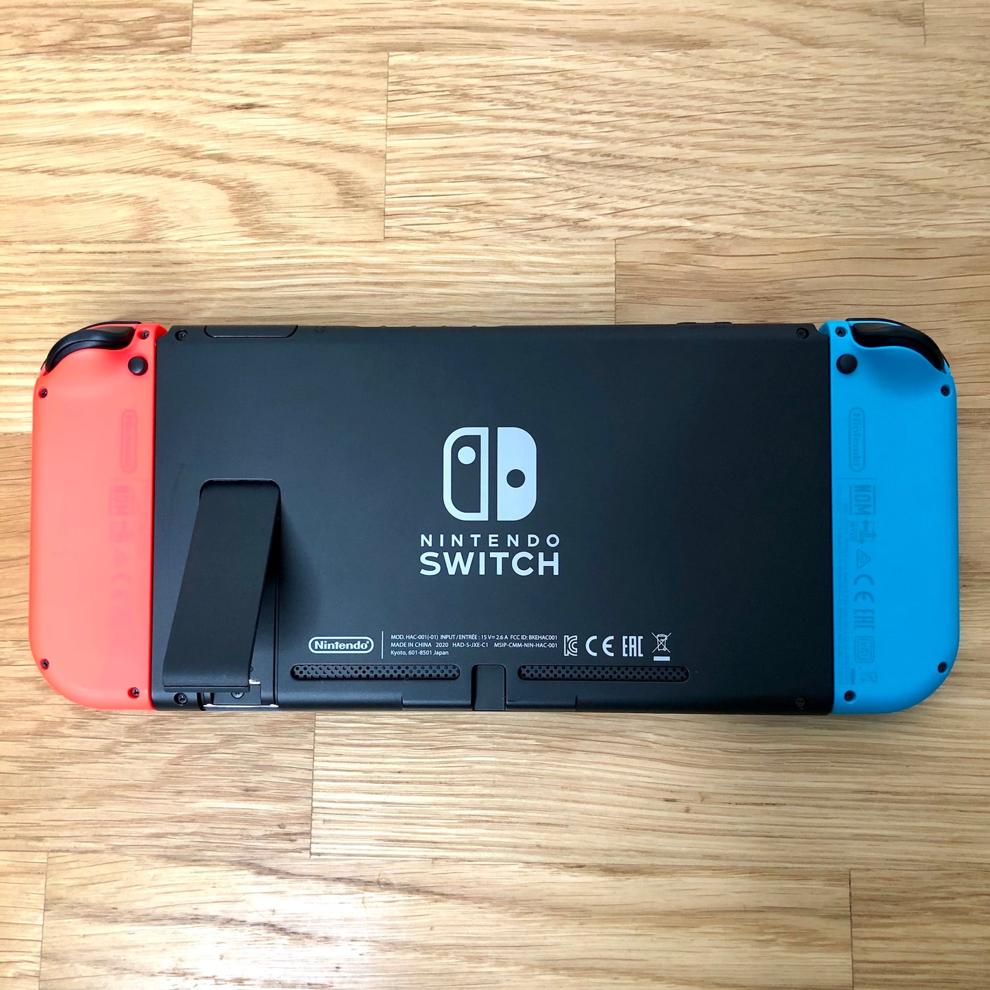 Rear of Nintendo Switch with kickstand open, showing logo, microSD card slot and dock connector.