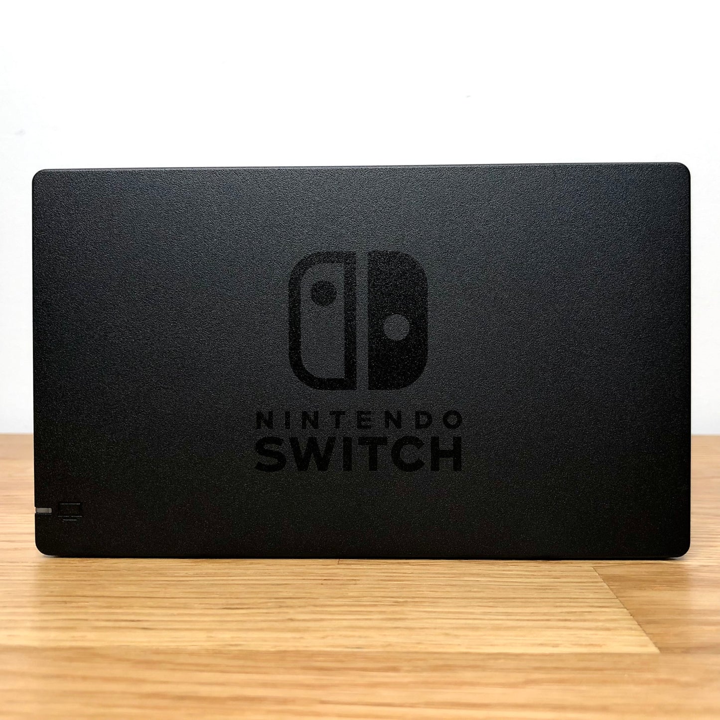 Front of Nintendo Switch dock with embossed logo, smooth matte finish and rounded edges.