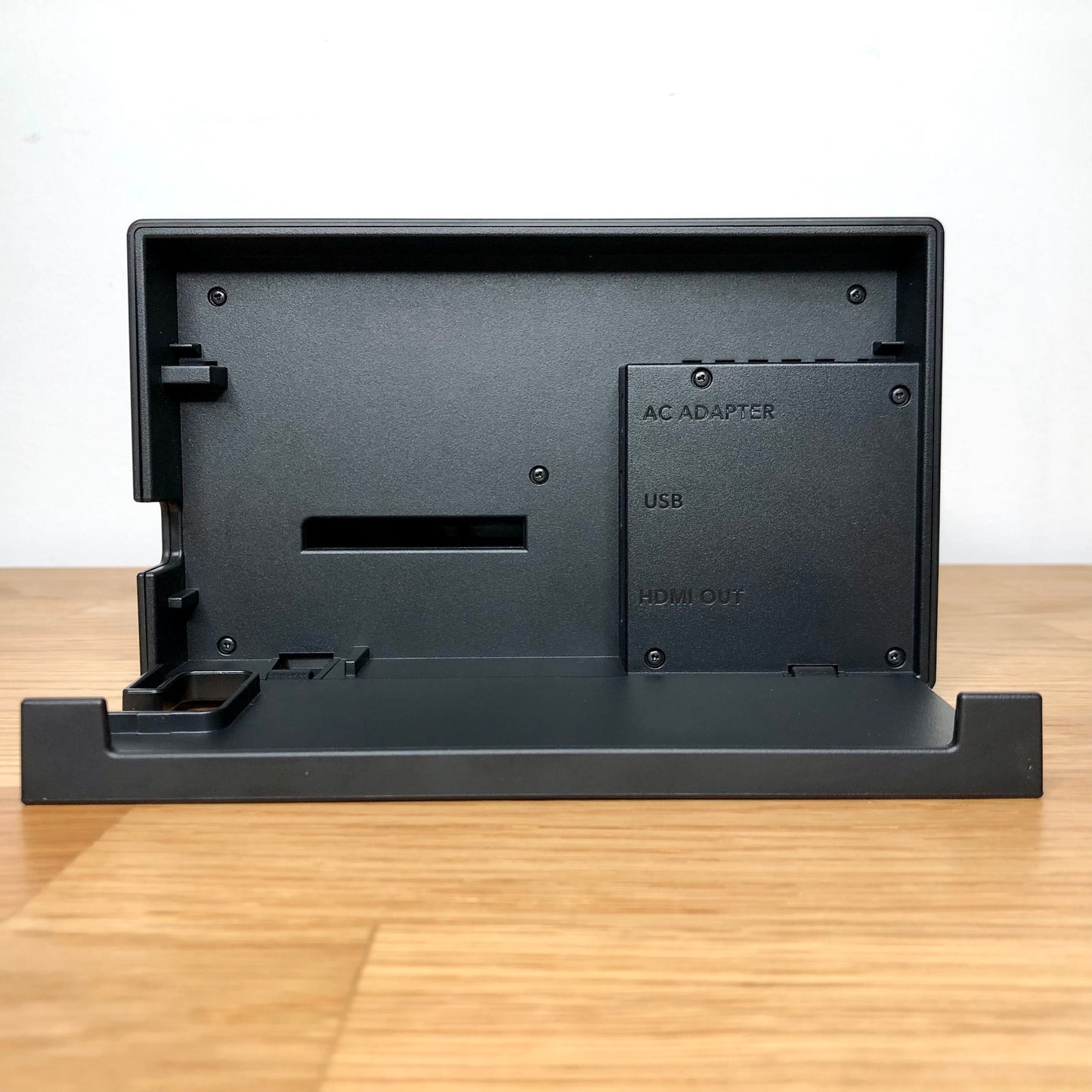 Inside of Nintendo Switch dock with flap open, showing ports for AC adapter, HDMI out and LAN.