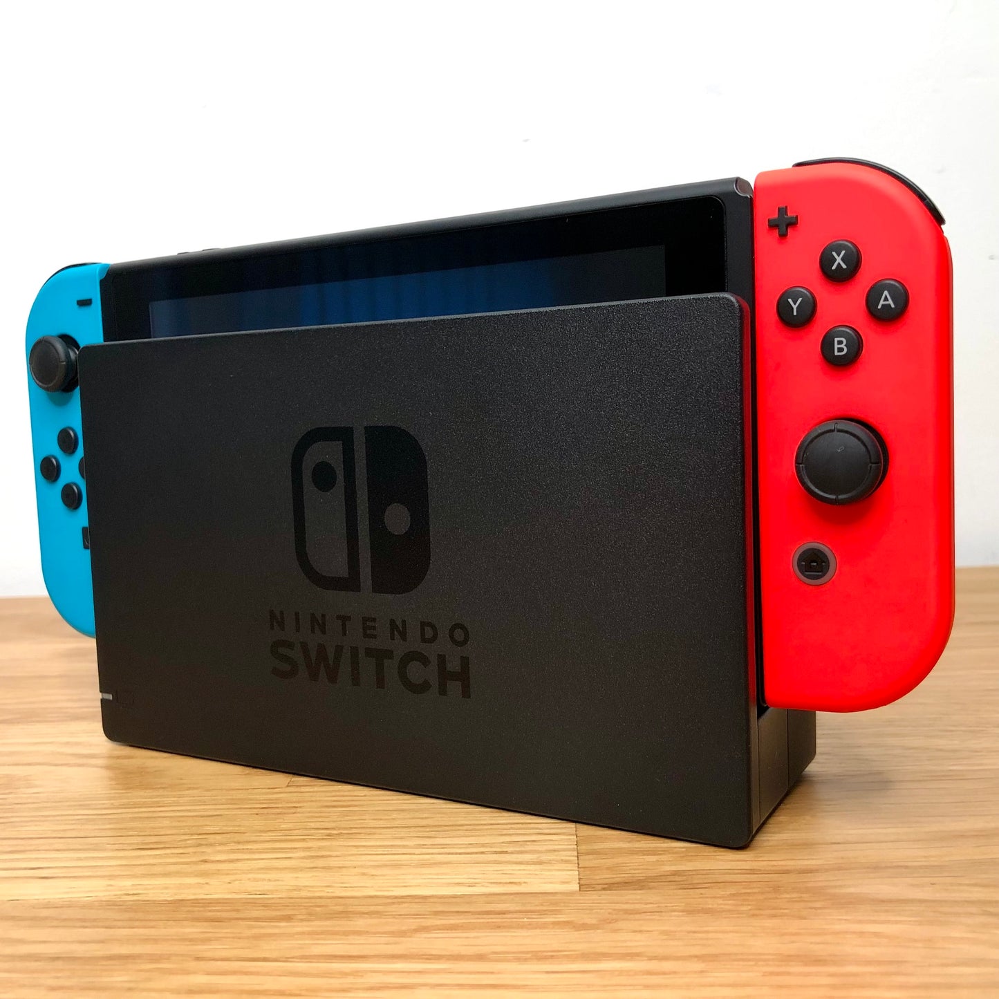 Angled right view of Nintendo Switch console docked with neon Joy-Cons, showing control sticks and front layout.