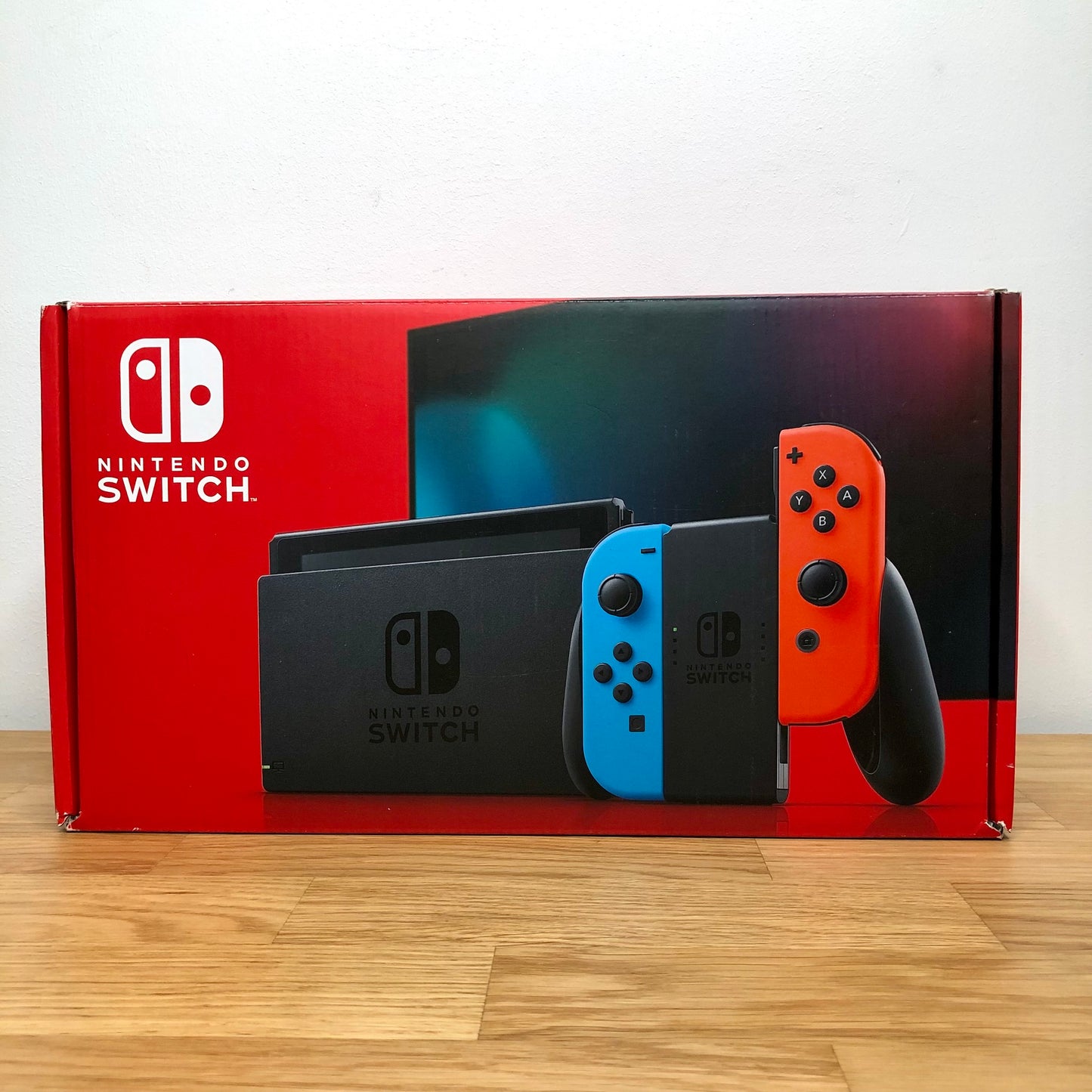Front of Nintendo Switch box showing red and blue Joy-Cons with console, vibrant screen artwork and red packaging.