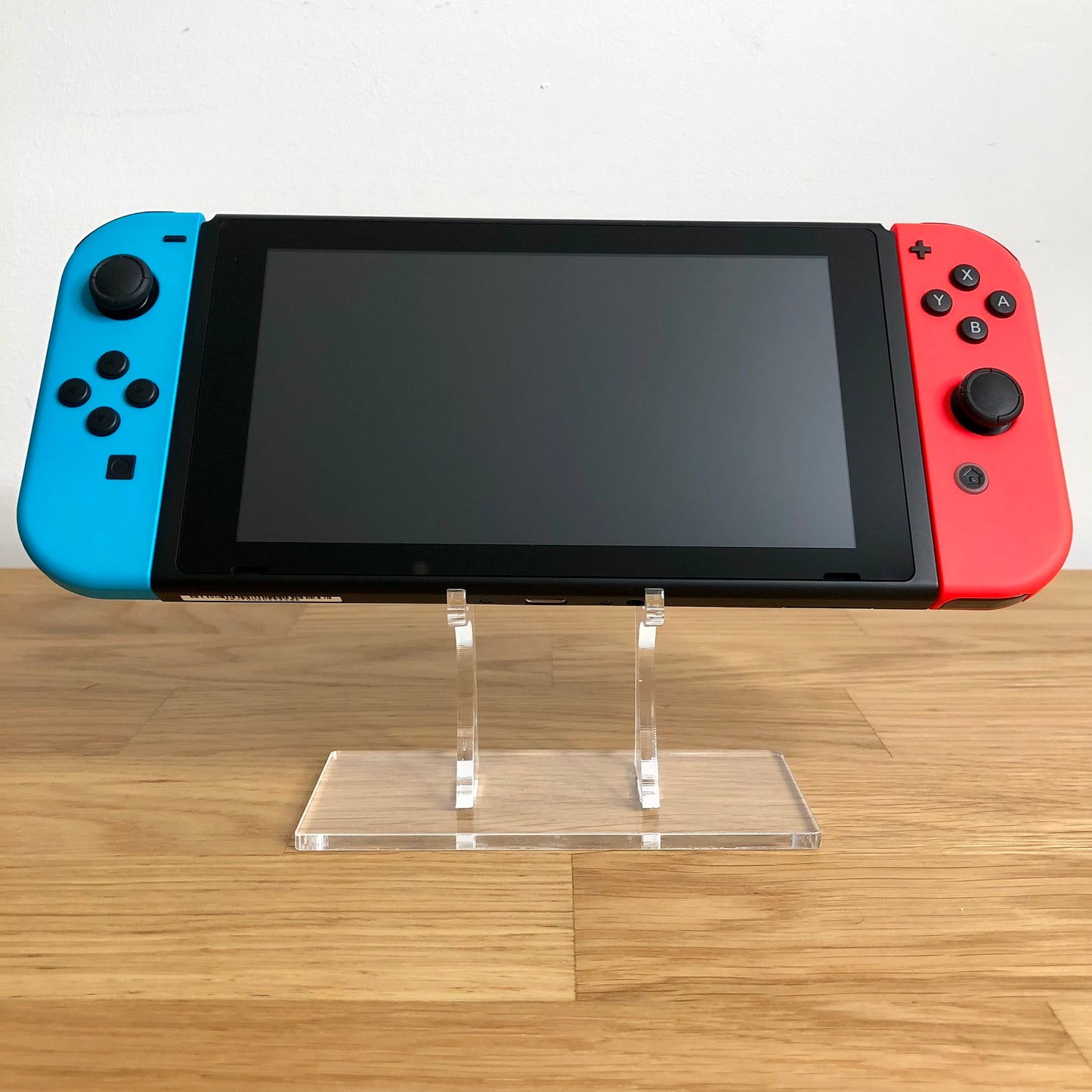 Front view of Nintendo Switch console with red and blue Joy-Cons attached, showing screen and face button layout.