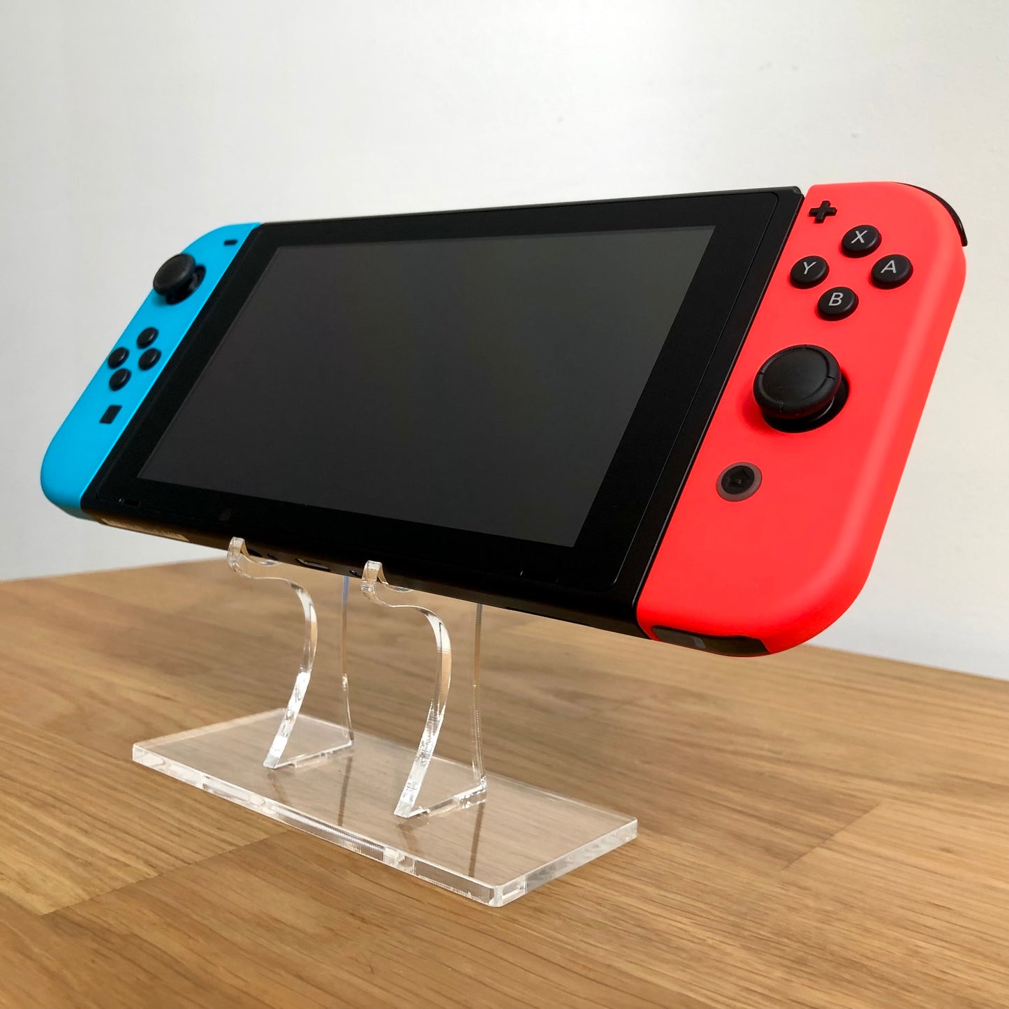 Angled front of Nintendo Switch with neon Joy-Cons, showing full face buttons, control sticks and screen.