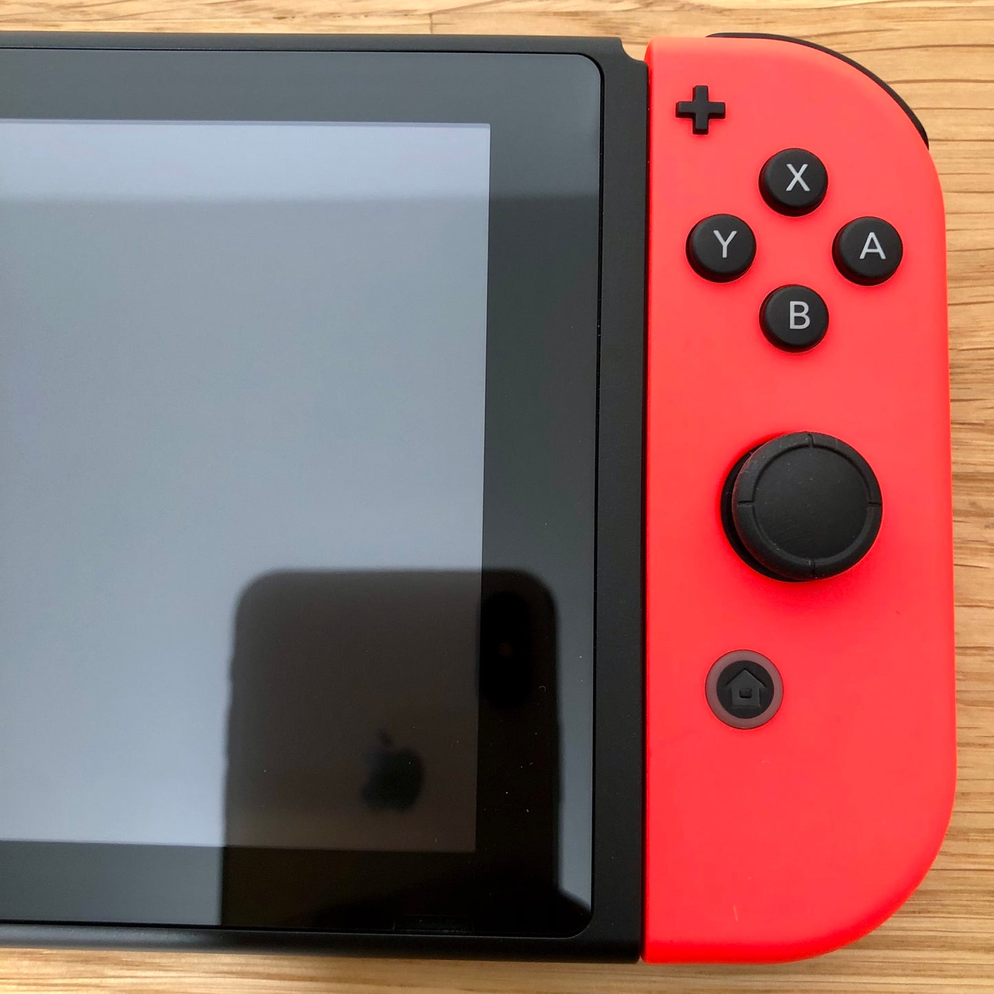 Close-up of neon red right Joy-Con on Nintendo Switch, showing A, B, X, Y buttons, stick, plus and home button.